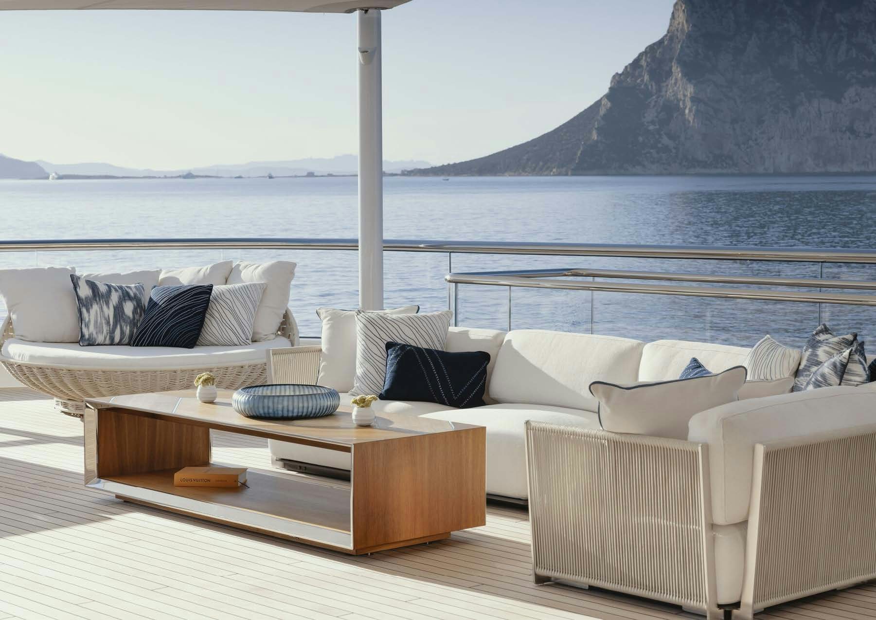 a living room with a large body of water in the background aboard H3 Yacht for Sale