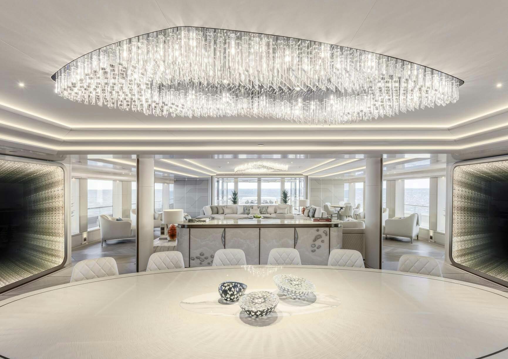 a large white room with a large table and chairs aboard H3 Yacht for Sale