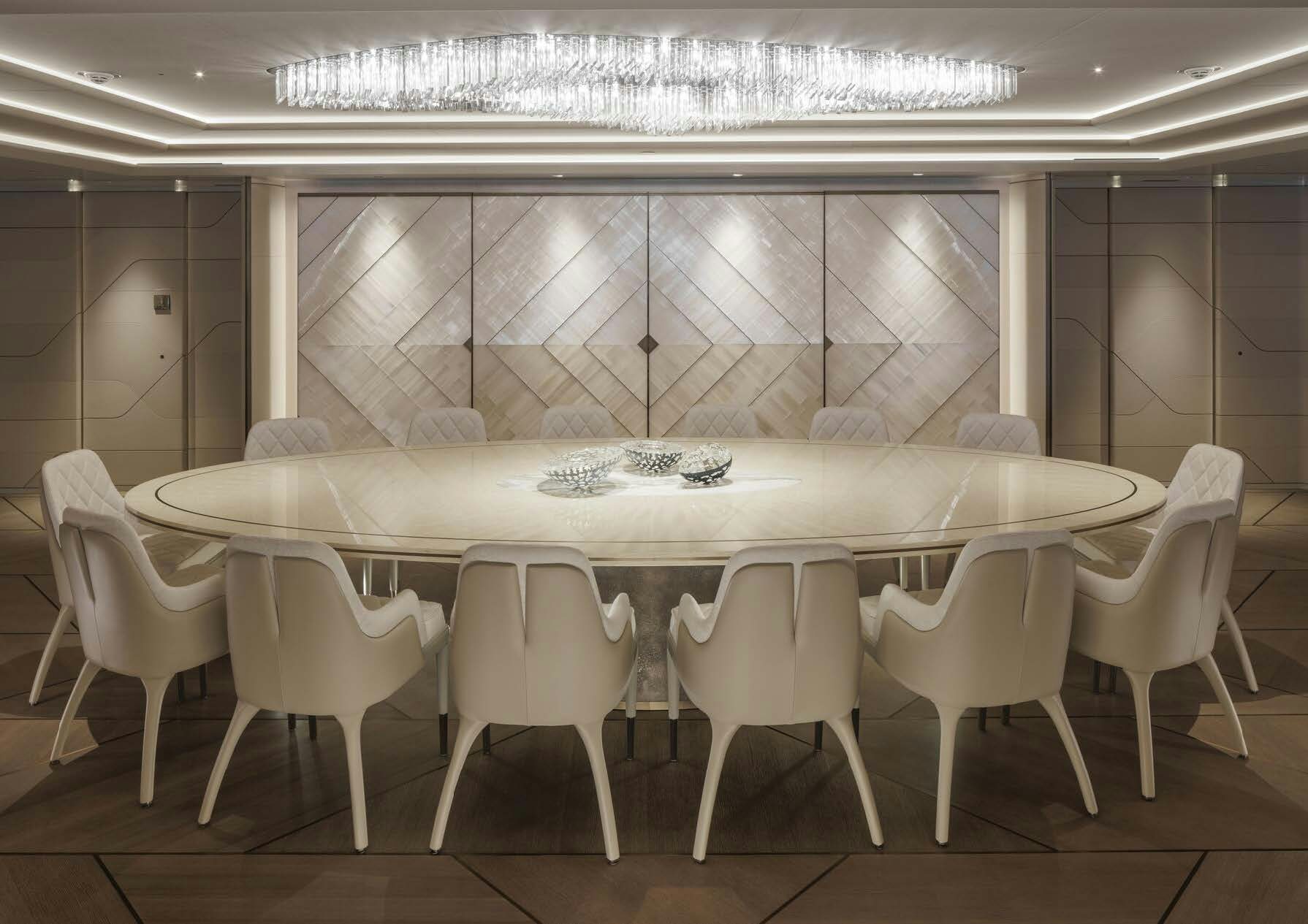 a row of white chairs in a room with a large white object on the wall aboard H3 Yacht for Sale
