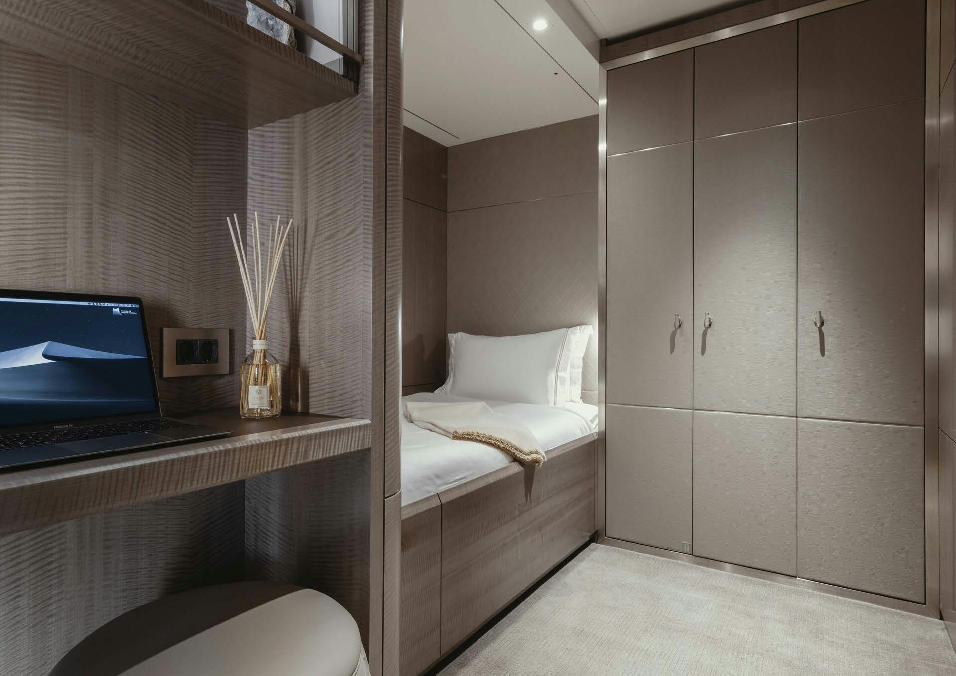 a bedroom with a laptop and a bed aboard H3 Yacht for Sale