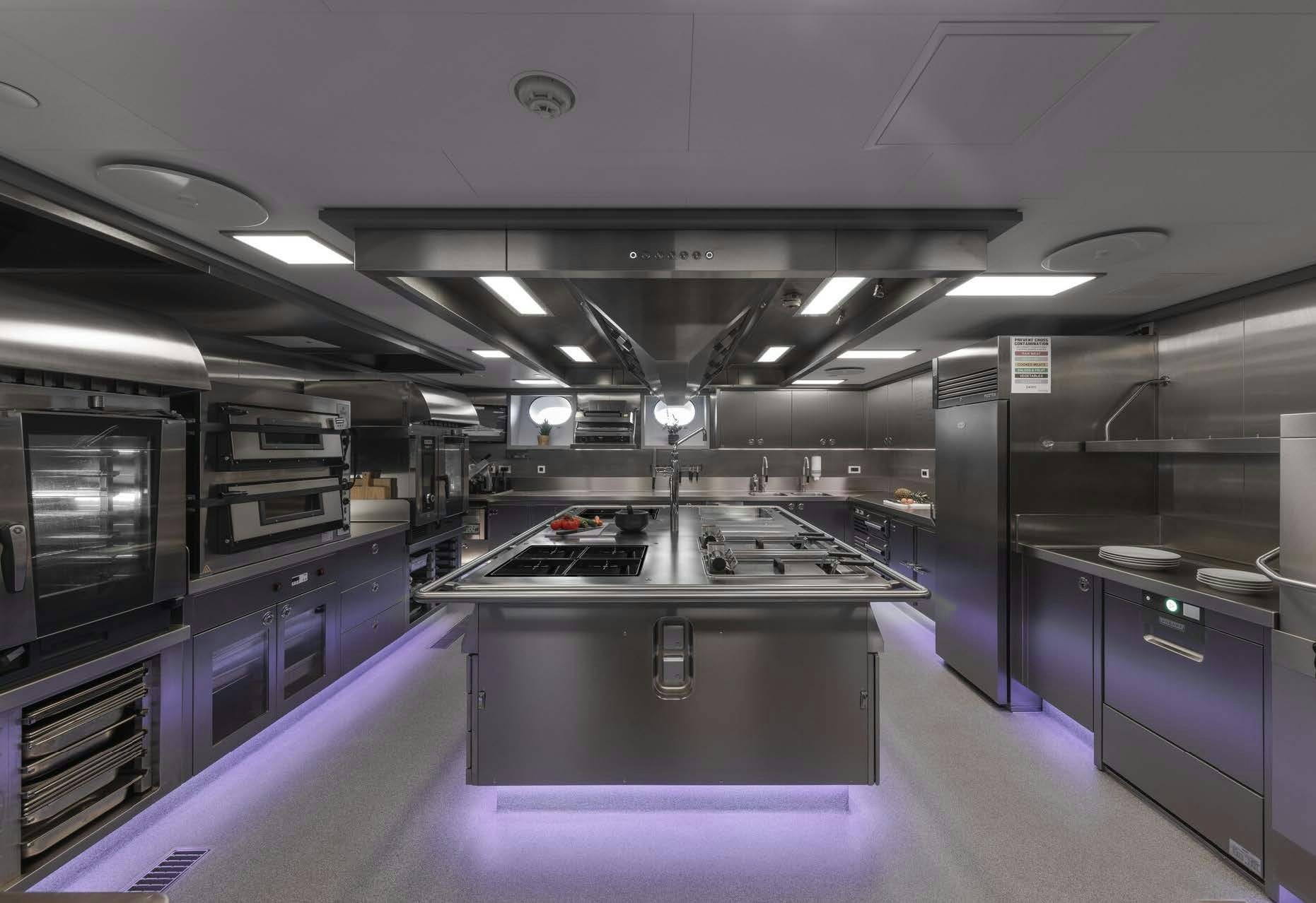 a large kitchen with purple cabinets aboard H3 Yacht for Sale