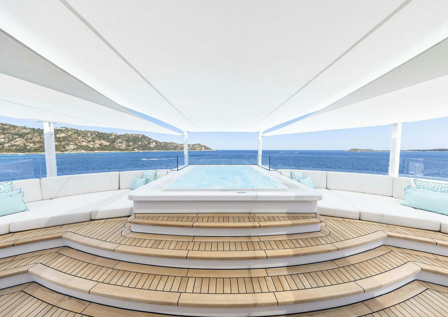 a white bed on a deck aboard H3 Yacht for Sale