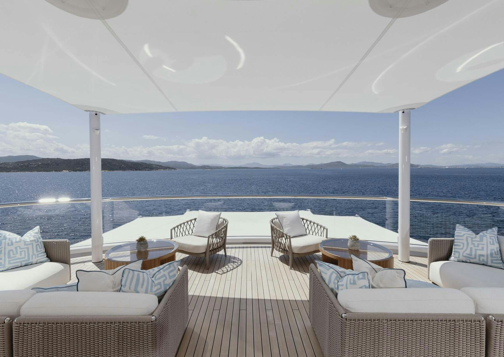 a deck with chairs and tables on it aboard H3 Yacht for Sale