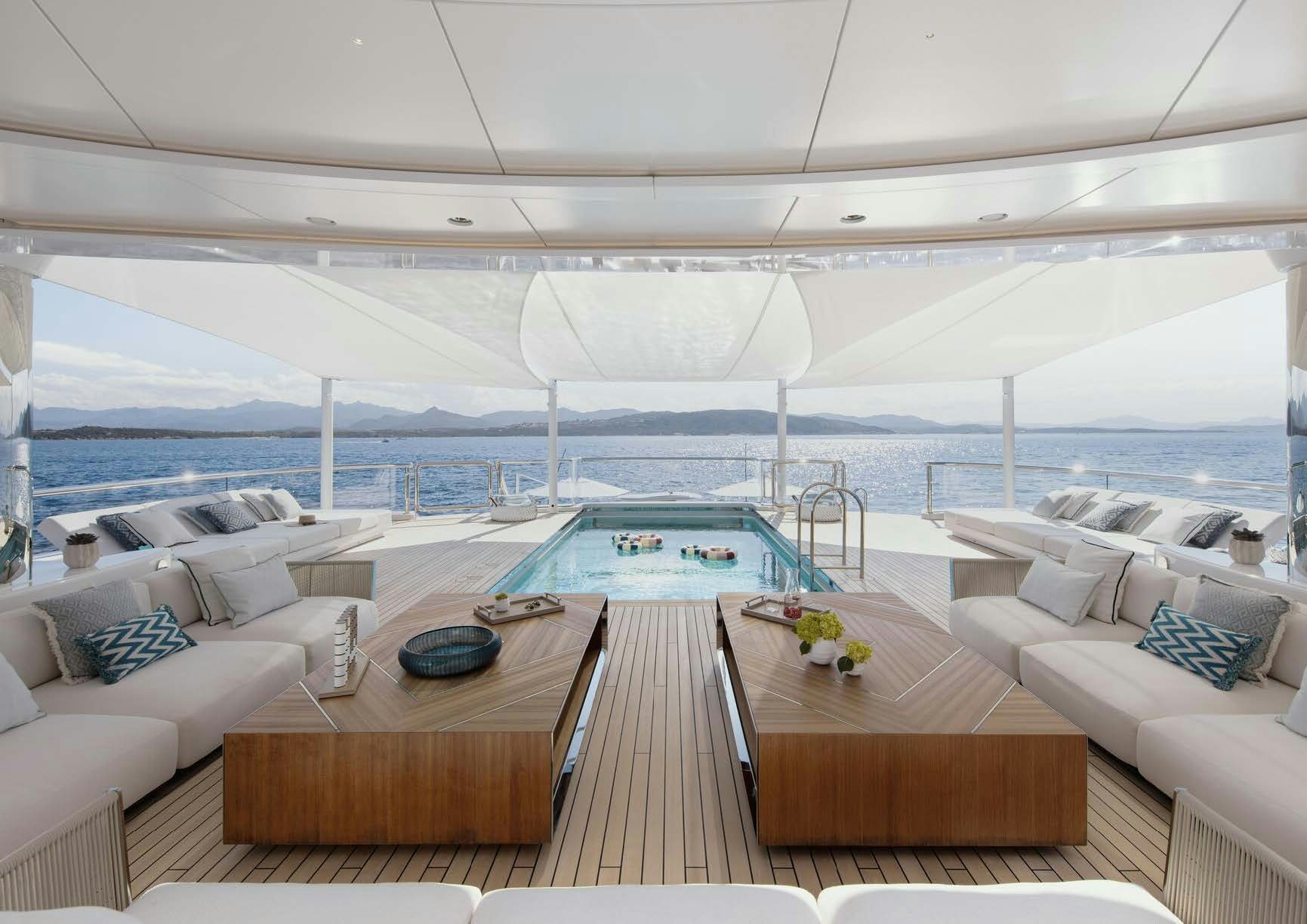 a large lounge area with a pool aboard H3 Yacht for Sale