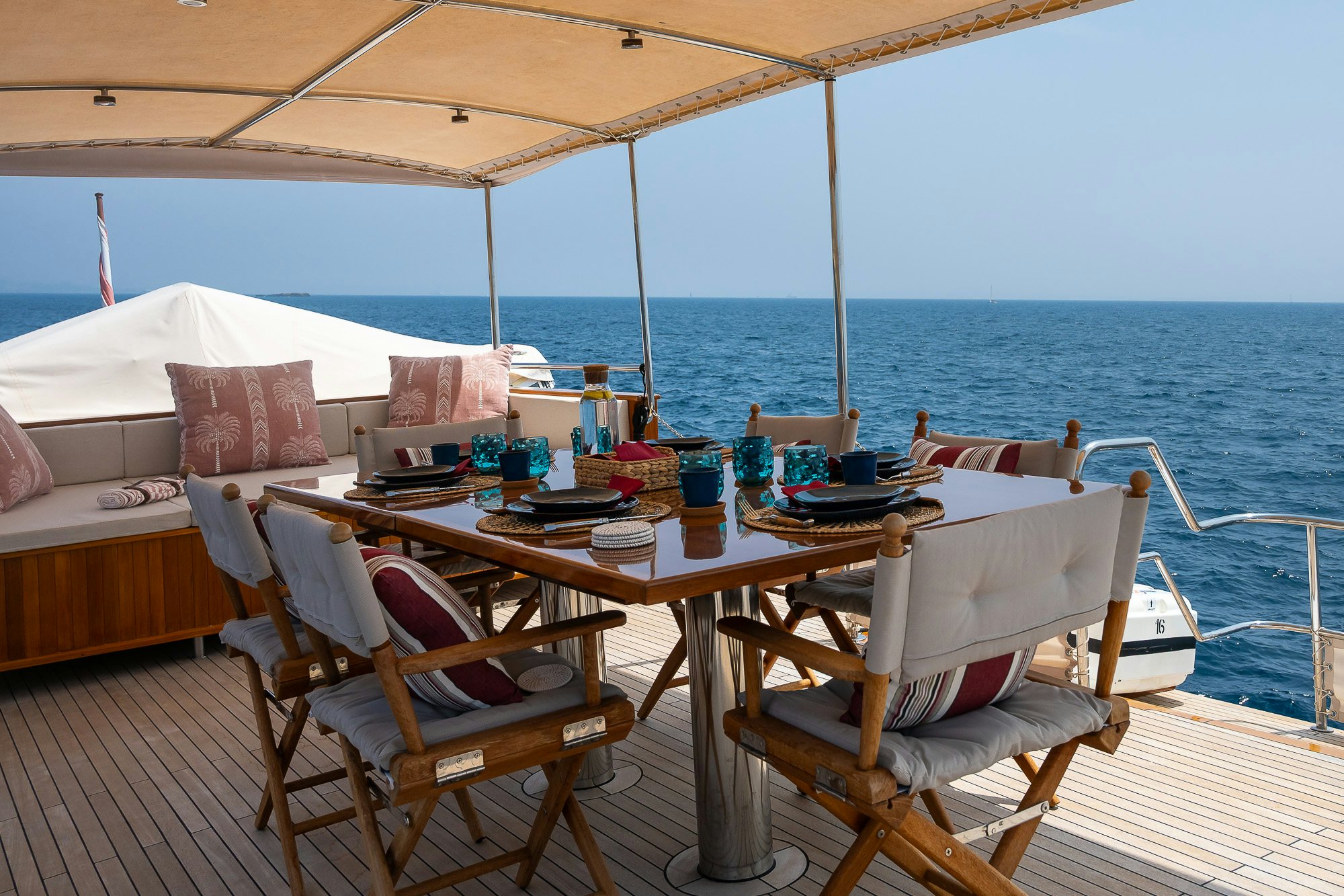 a table with chairs on it next to a large body of water aboard BLACK PEPPER Yacht for Sale