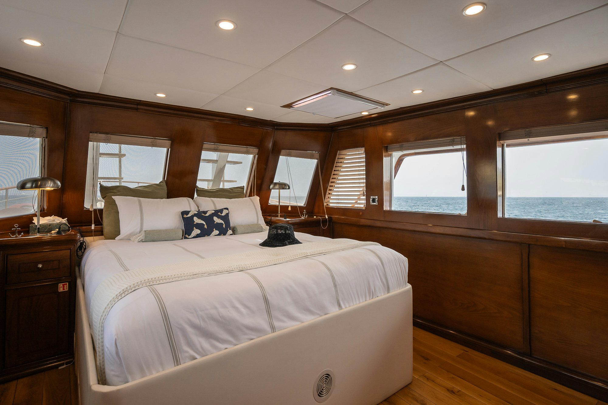 a bedroom with a bed and a window aboard BLACK PEPPER Yacht for Sale