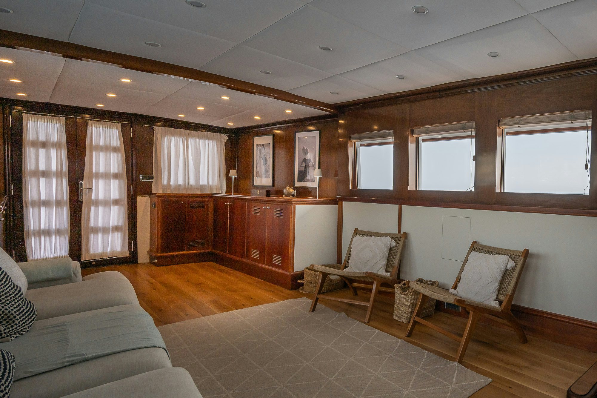 a living room with wood furniture aboard BLACK PEPPER Yacht for Sale