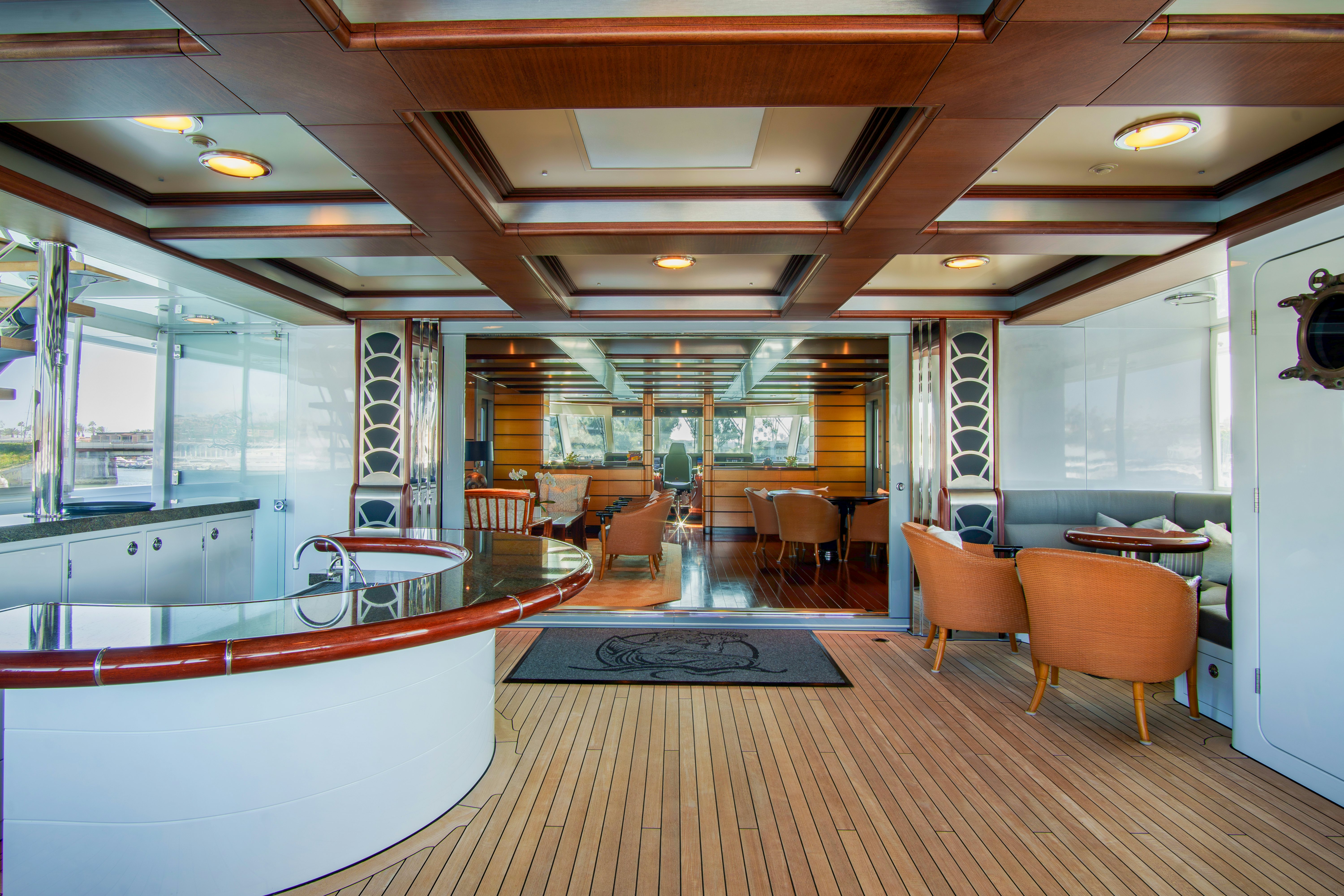 a large room with a wood floor and a table and chairs aboard TRITON Yacht for Charter