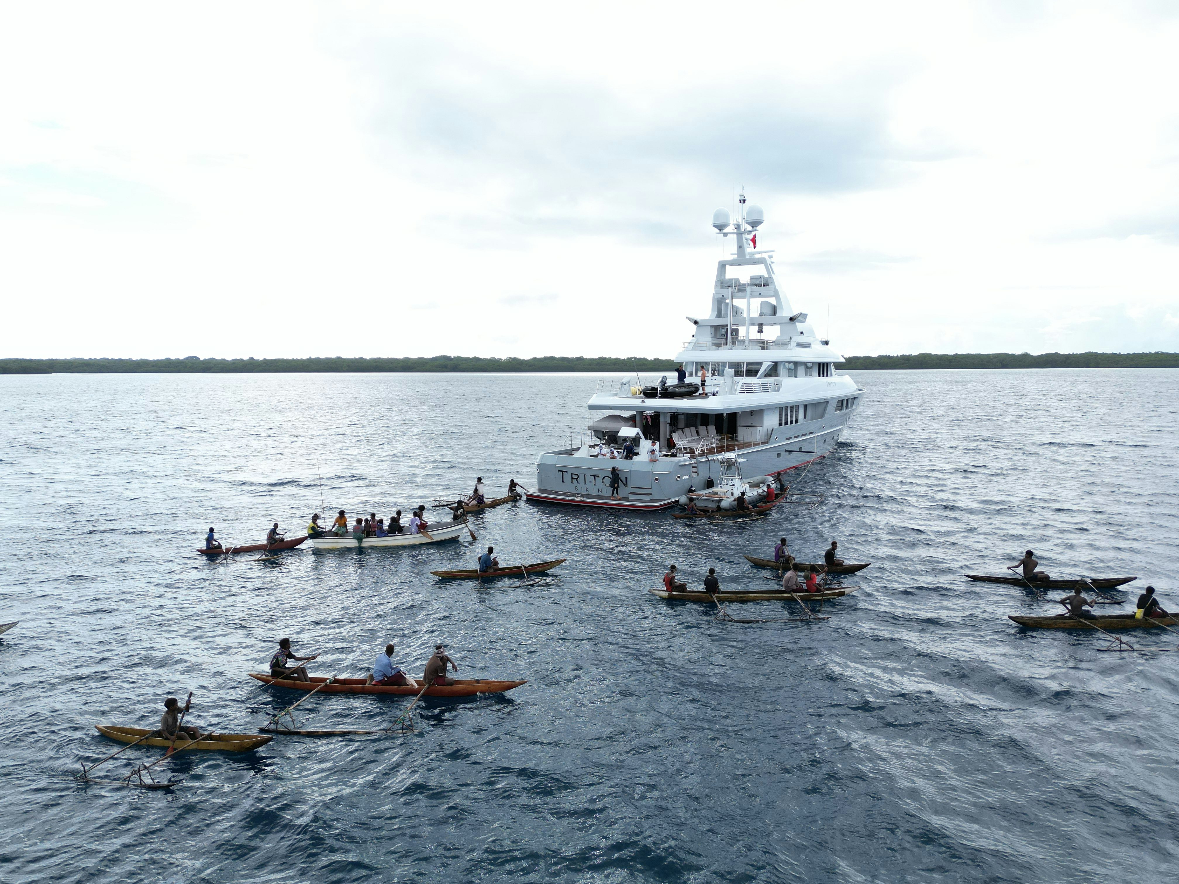 a group of people rowing boats on the water aboard TRITON Yacht for Charter