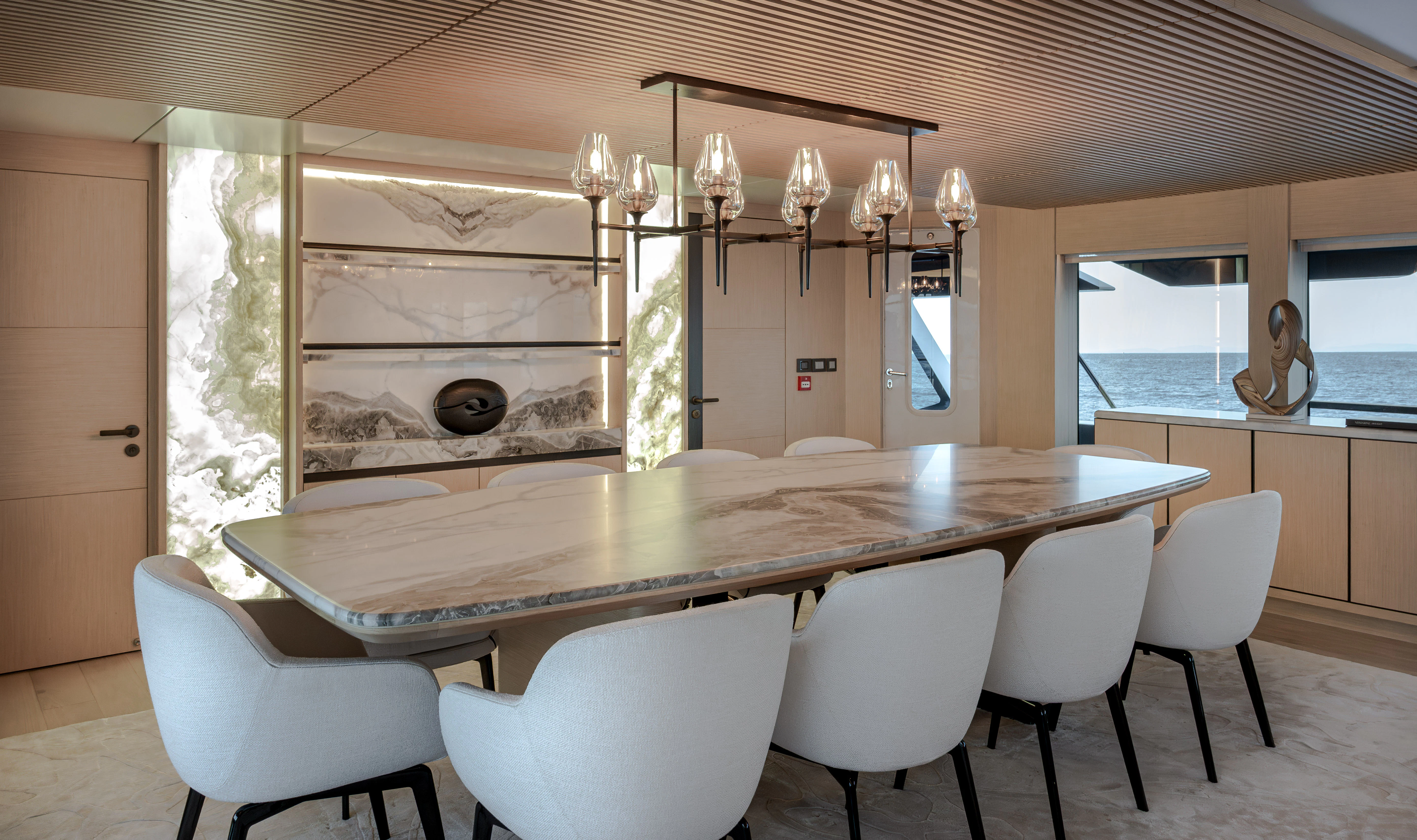 a large dining table with white chairs aboard ORPHEUS Yacht for Sale