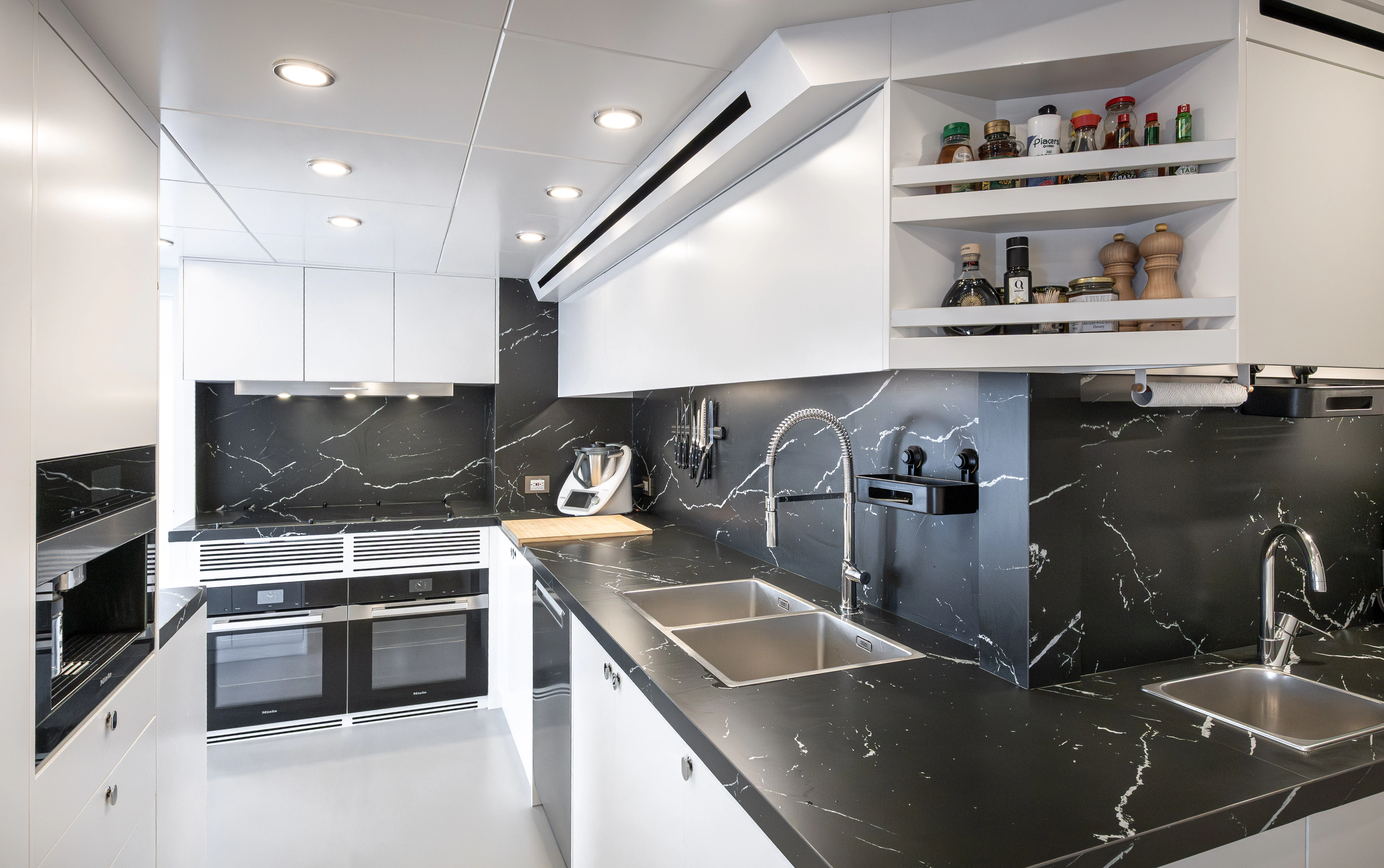 a kitchen with black counter tops aboard ORPHEUS Yacht for Sale