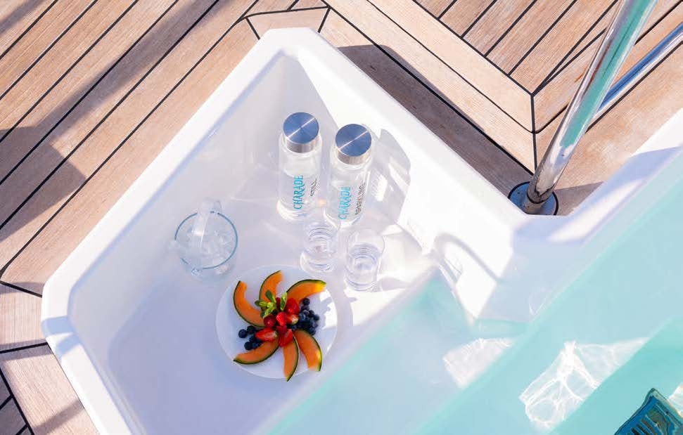 a table with a plate of food and a bottle of water aboard CHARADE Yacht for Charter