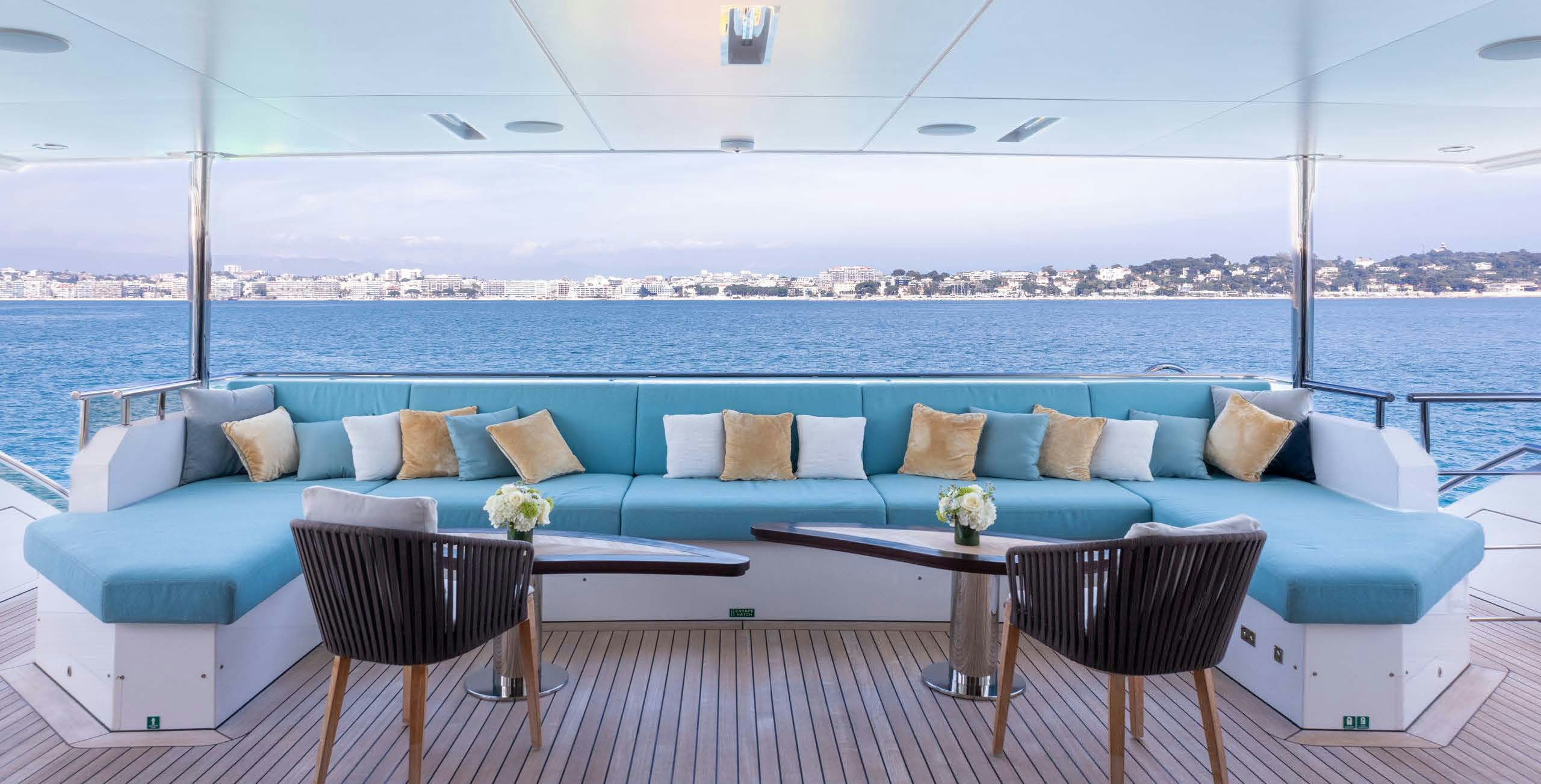 a couch and chairs on a balcony aboard CHARADE Yacht for Charter