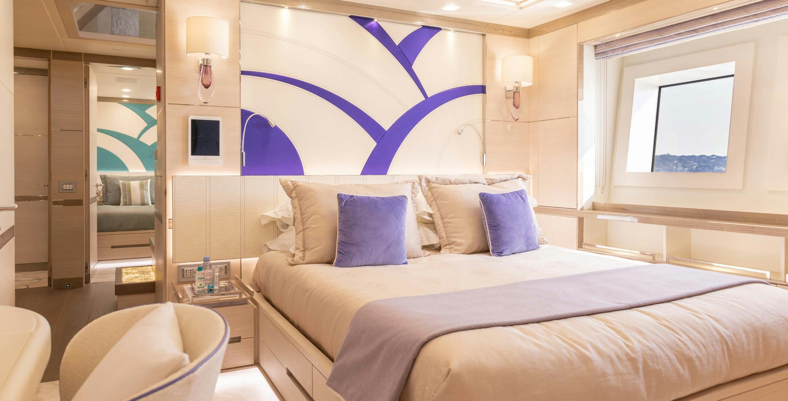 a bed with a painting on the wall aboard CHARADE Yacht for Charter