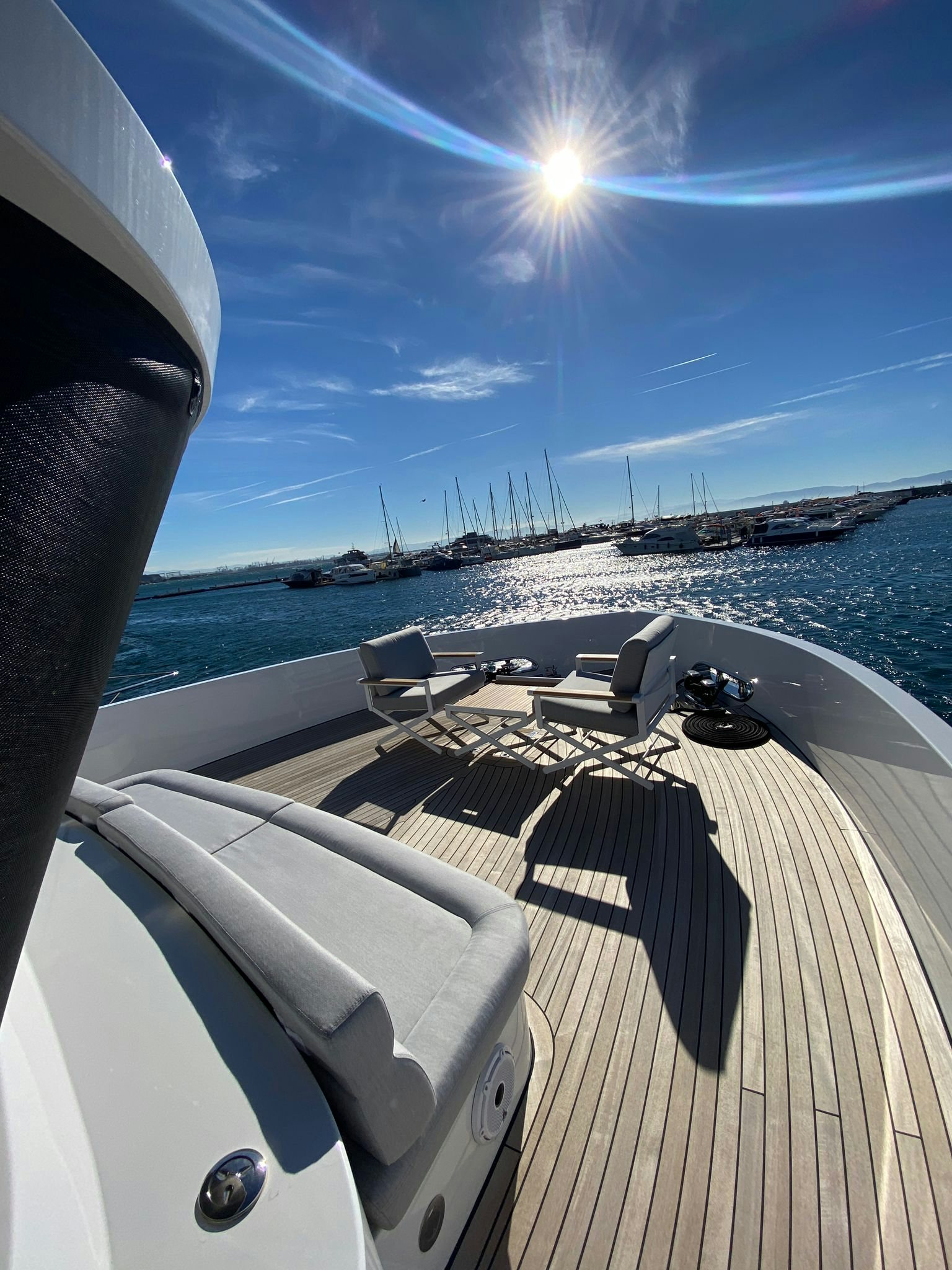 a deck with chairs and a body of water in the background aboard ZIMA Yacht for Sale