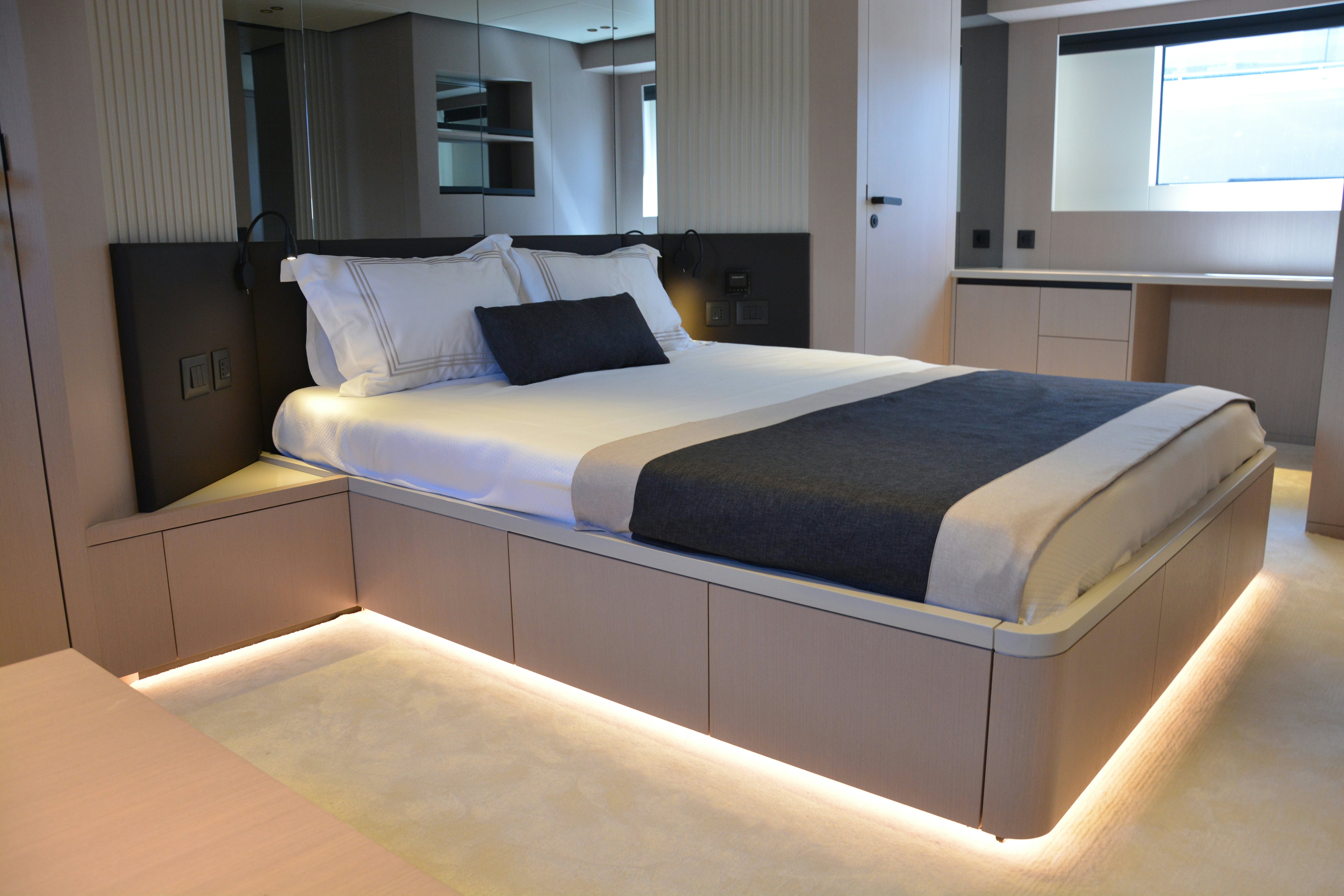 a bed with a black and white pillow on it aboard ZIMA Yacht for Sale