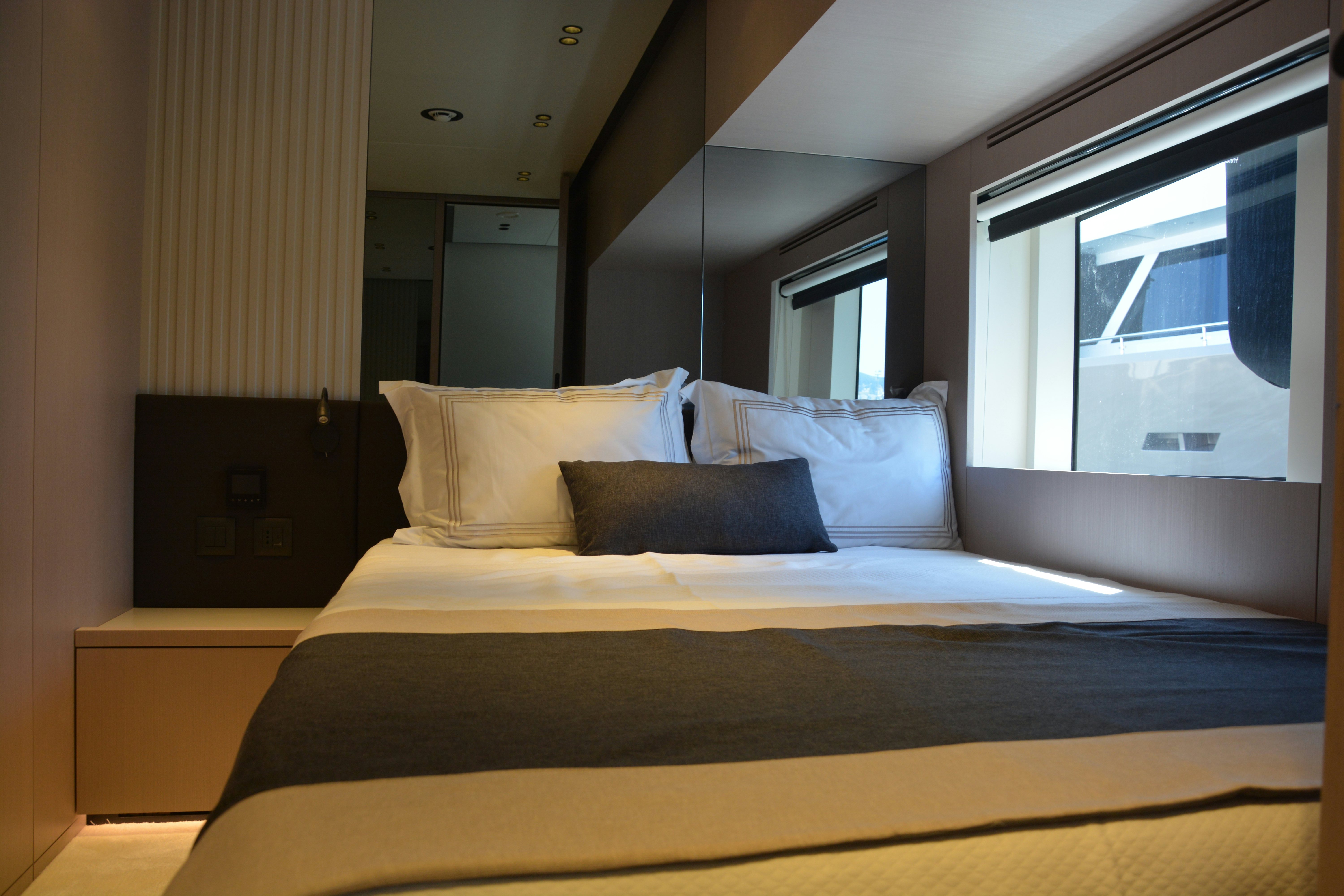 a bed with a white sheet and pillows aboard ZIMA Yacht for Sale