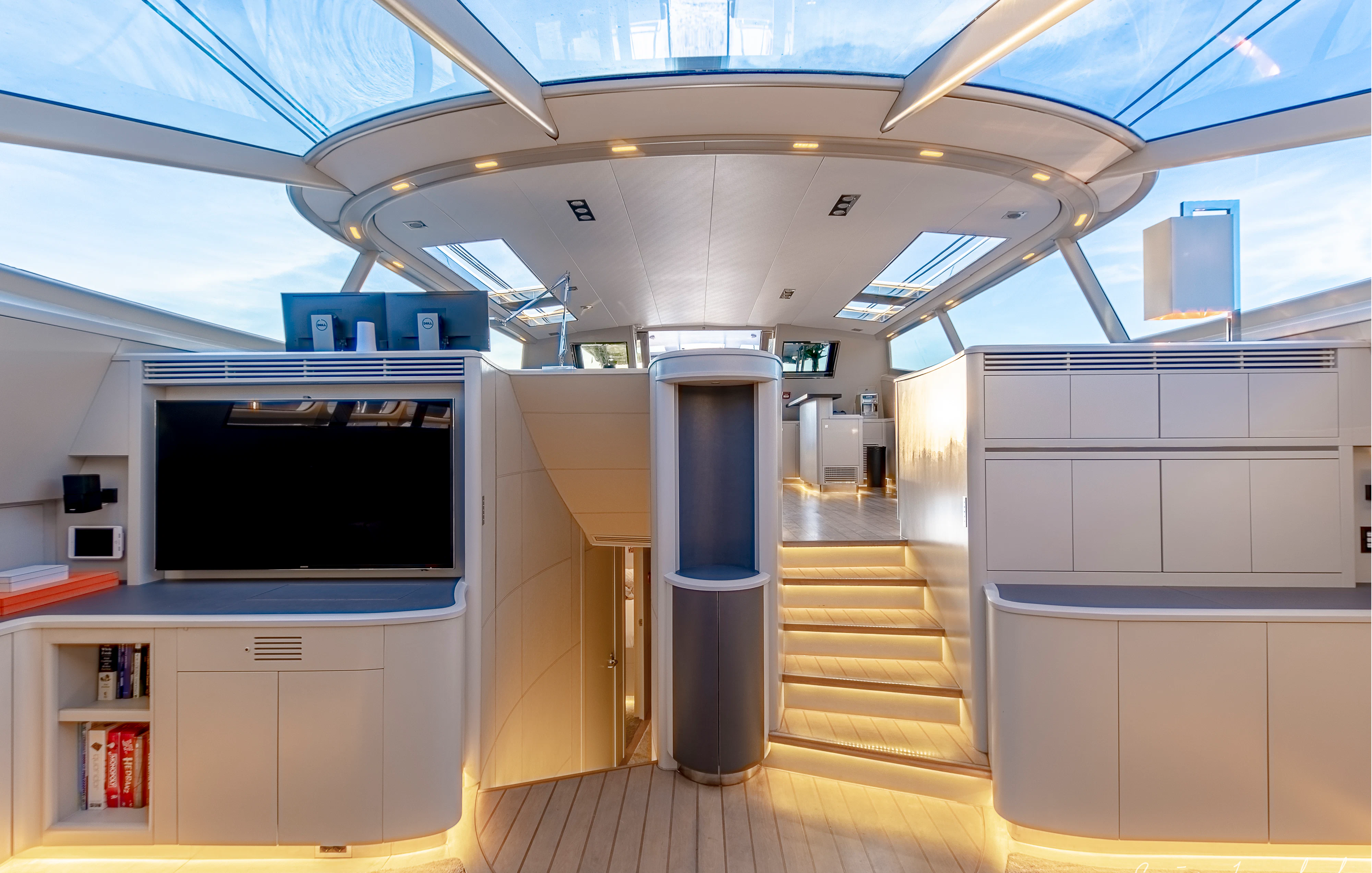 a room with a tv and a shelf with books aboard MY STAR Yacht for Sale