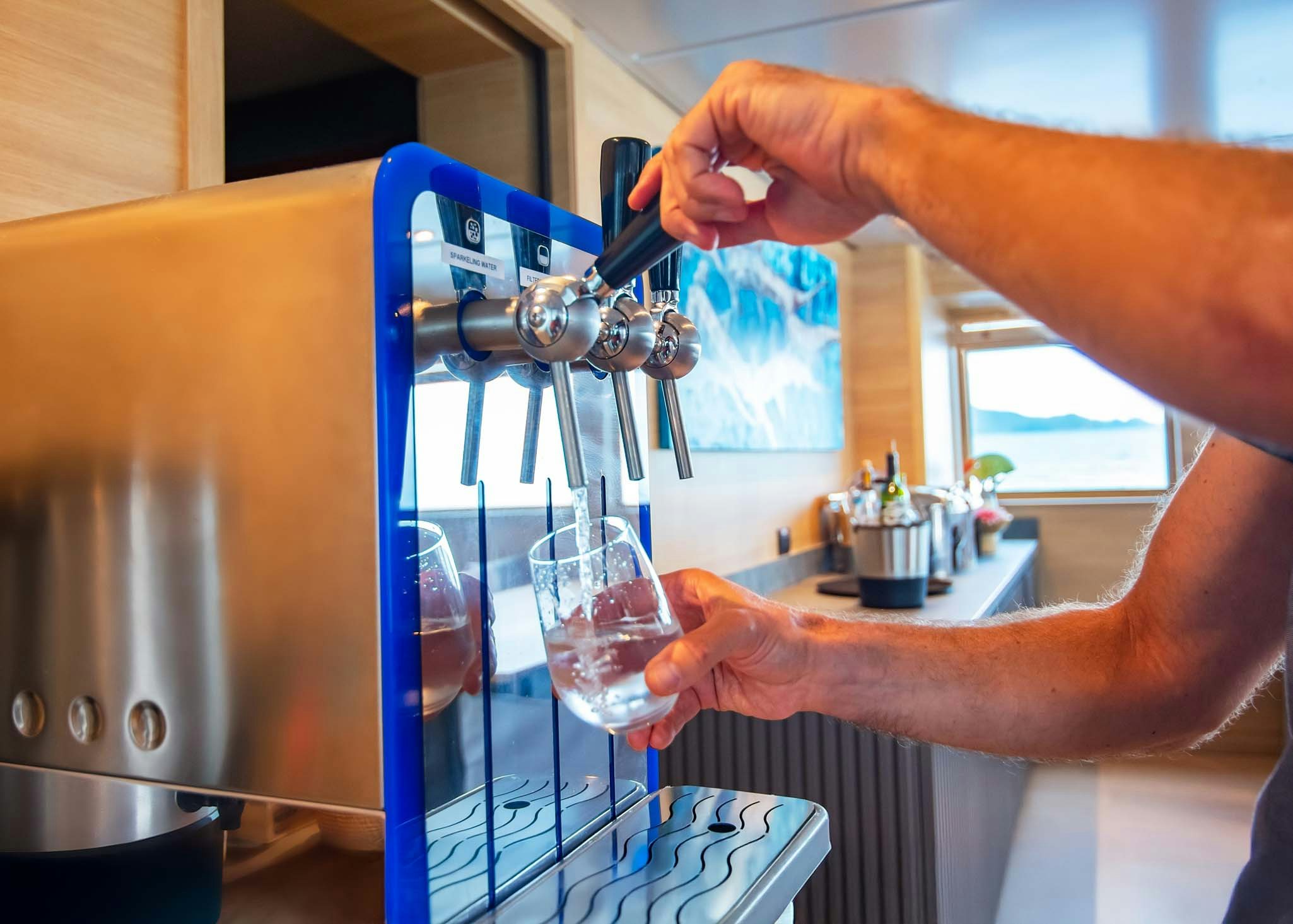 a person pouring a liquid into a glass aboard TRIBUTE - FREDDY'S LEGACY Yacht for Charter