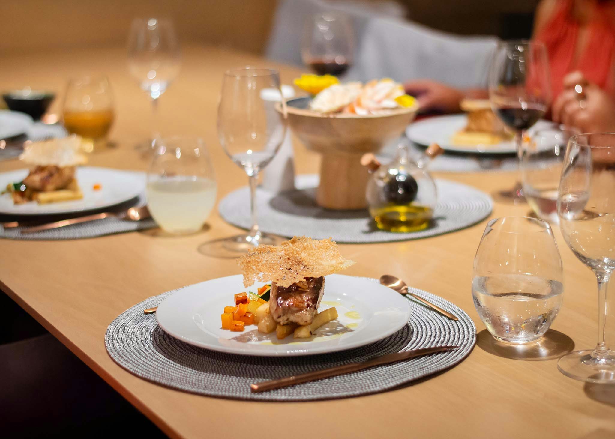 a table with plates of food and glasses of wine aboard TRIBUTE - FREDDY'S LEGACY Yacht for Charter