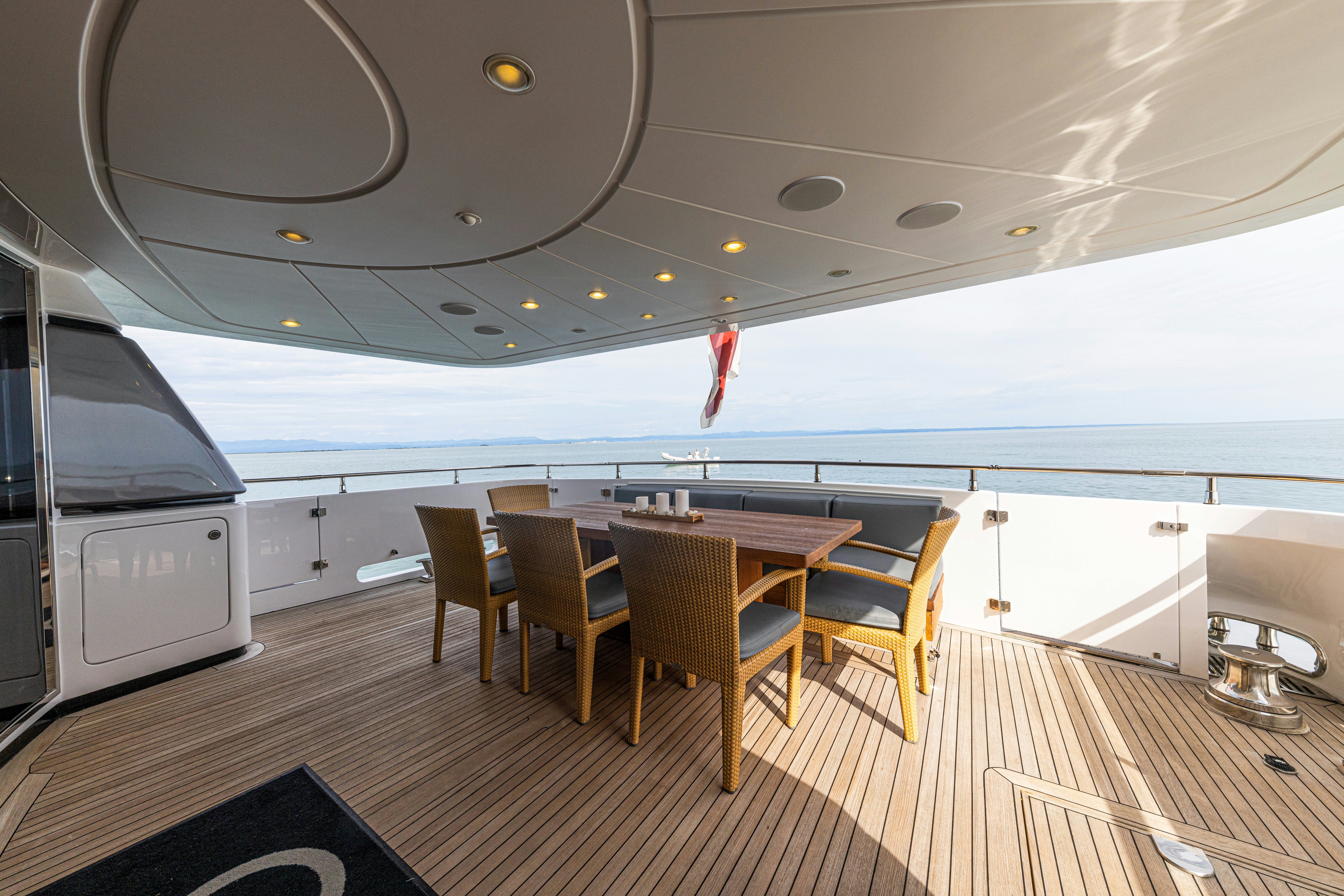 a large boat with a table and chairs on the deck aboard TAURO Yacht for Sale