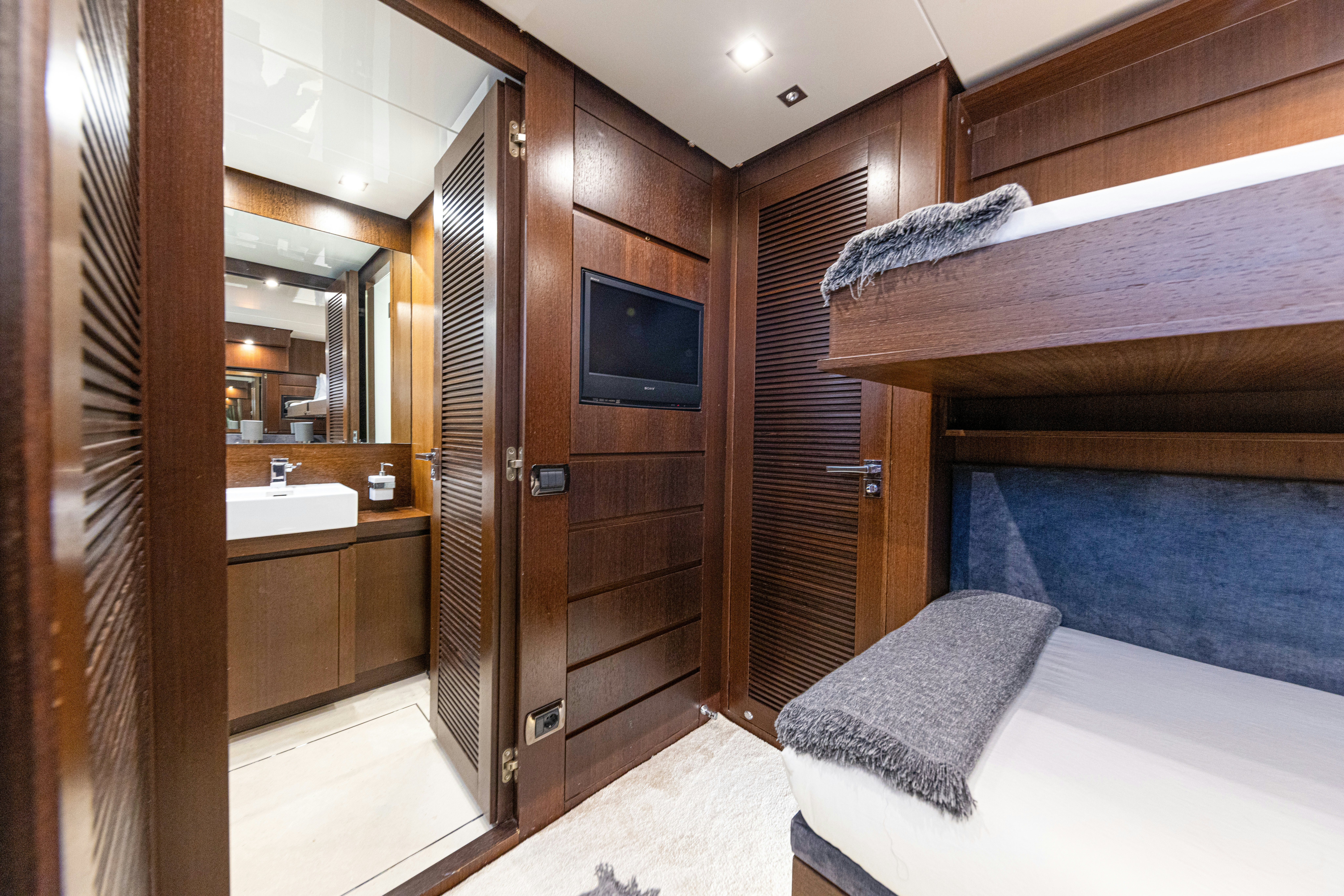 a room with a bed and a television aboard TAURO Yacht for Sale