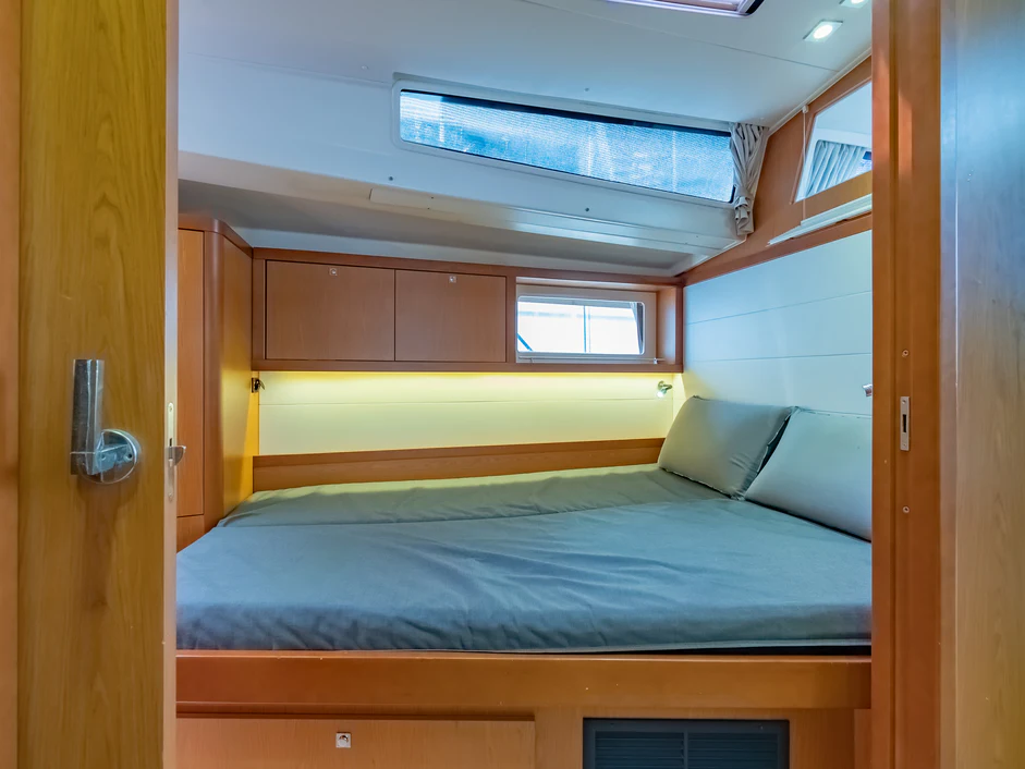 a bed with a blue comforter aboard IMPERIA Yacht for Sale