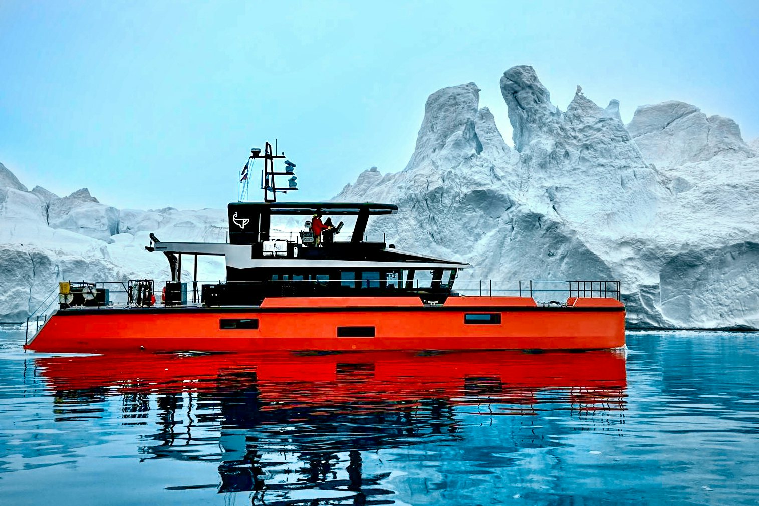 a boat in the water with icebergs in the background aboard VANGUARD Yacht for Sale