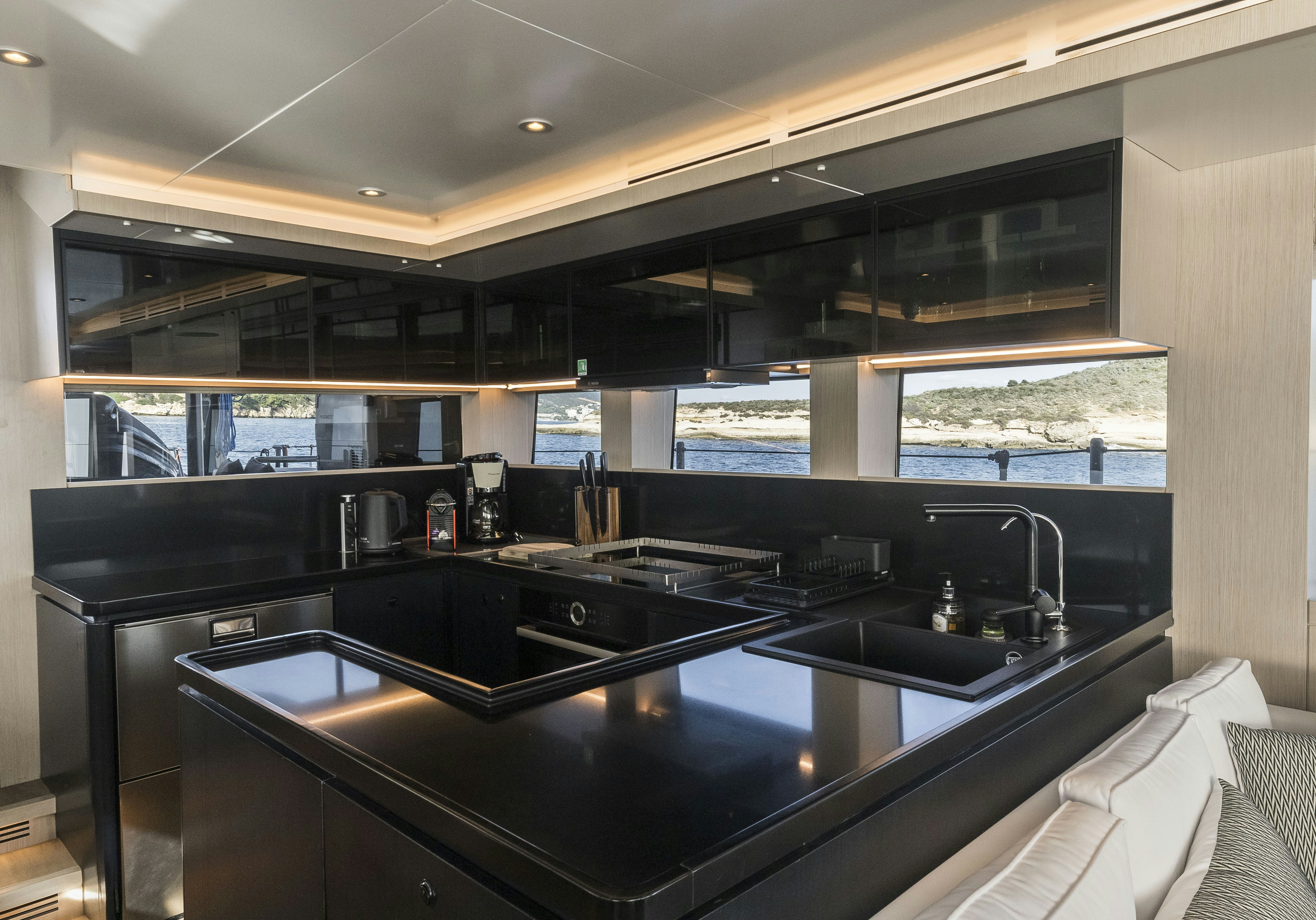 a kitchen with black appliances aboard VANGUARD Yacht for Sale
