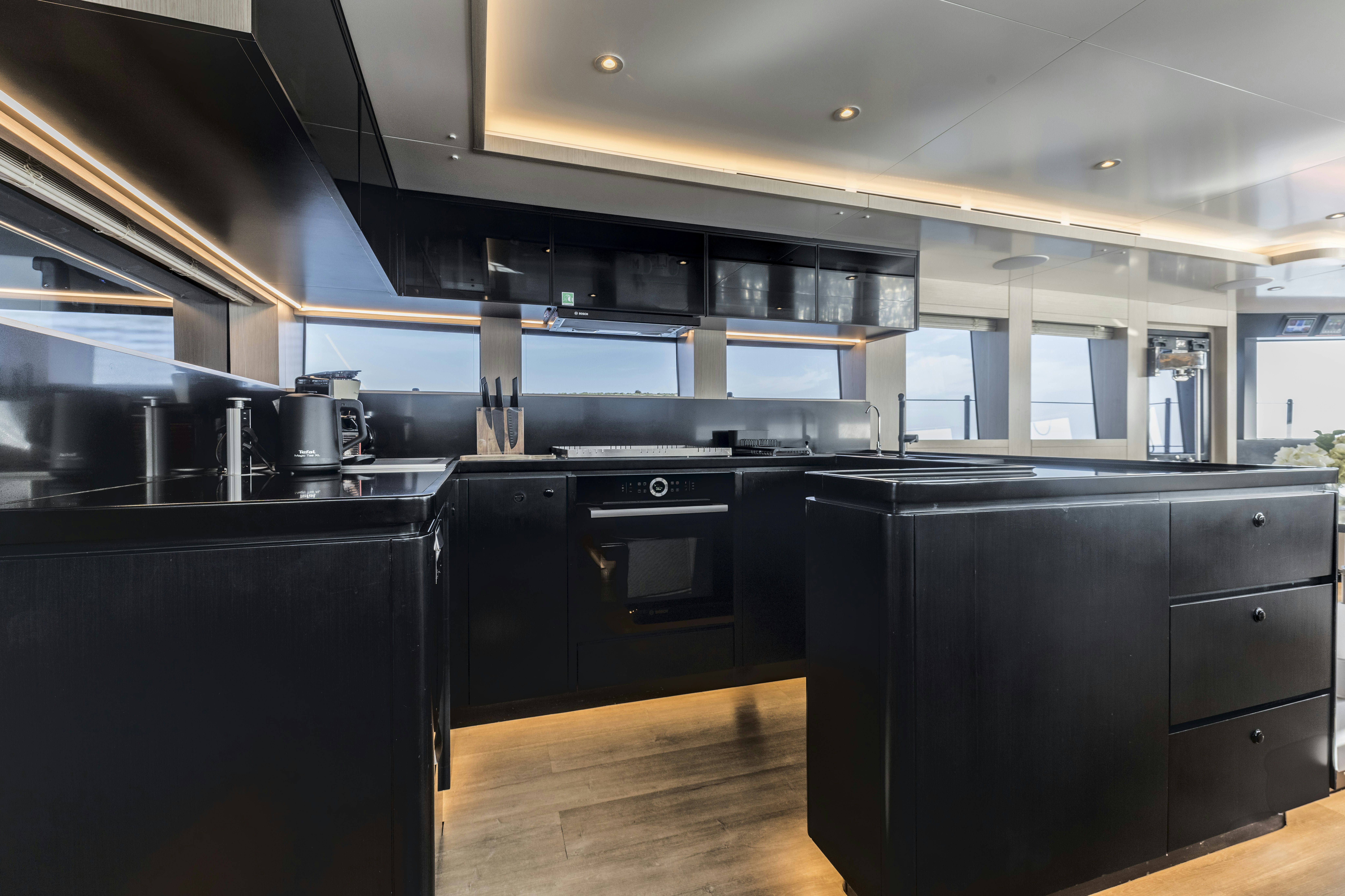 a kitchen with black appliances aboard VANGUARD Yacht for Sale