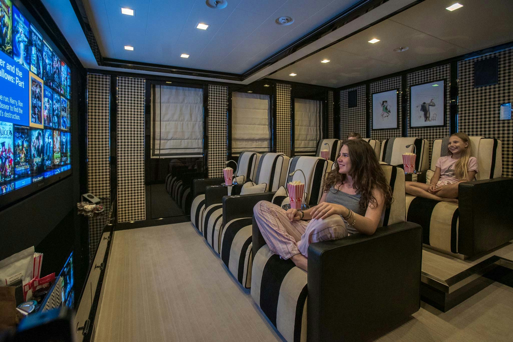 a group of people sitting in chairs in a room with a tv aboard AXIOMA Yacht for Charter