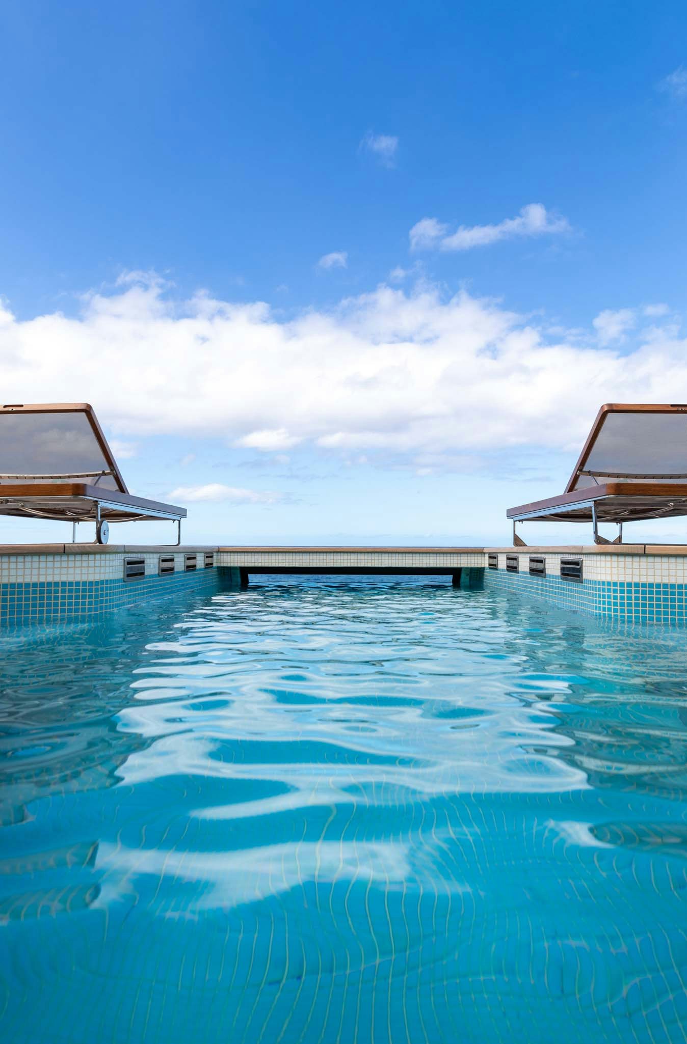 a pool with a building in the background aboard AXIOMA Yacht for Charter