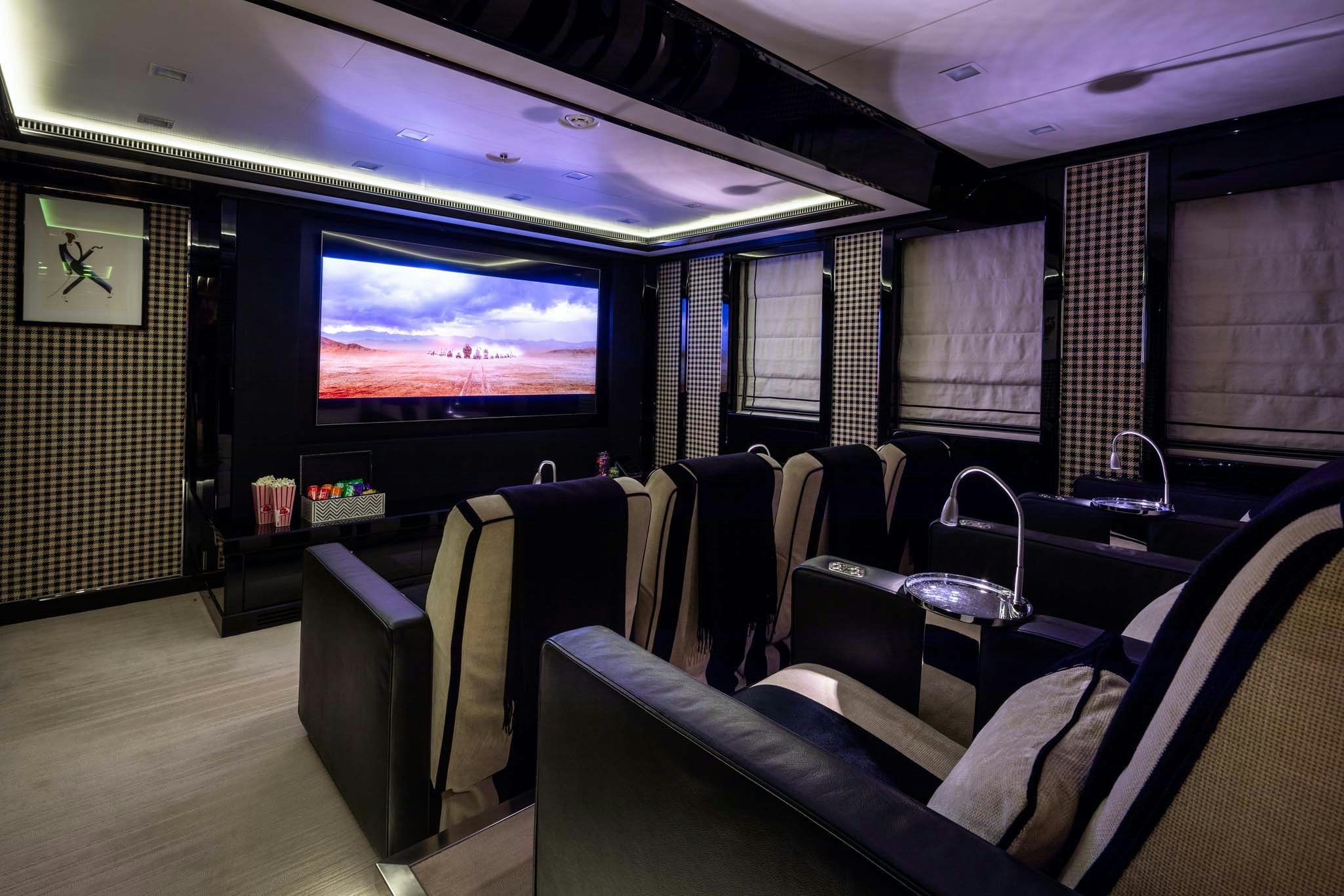 a room with chairs and a tv aboard AXIOMA Yacht for Charter