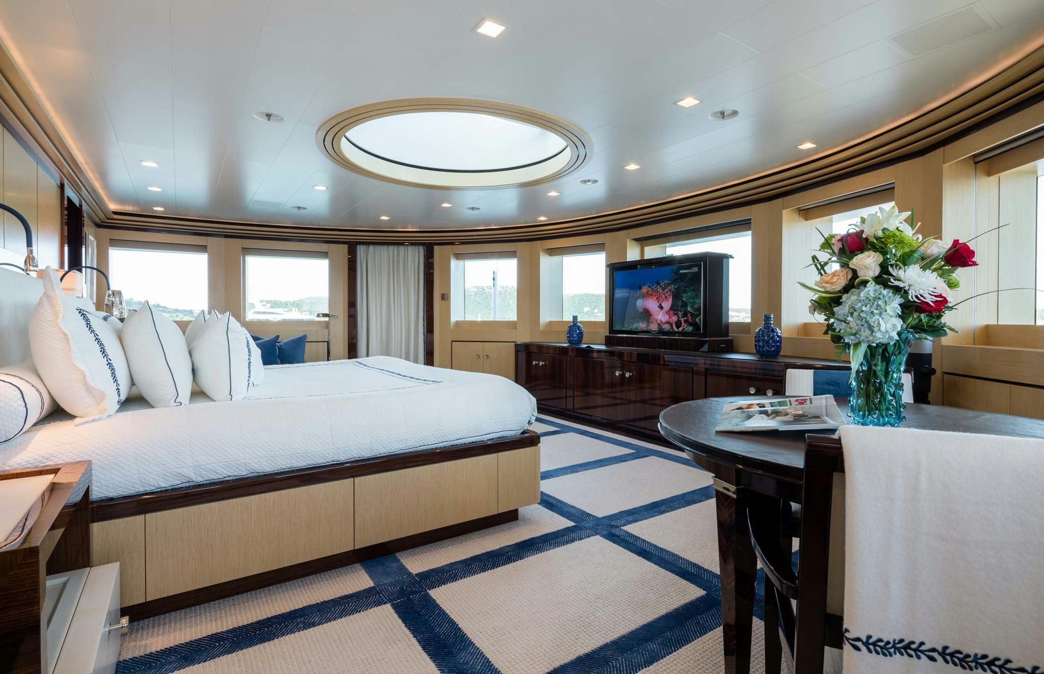 a large bedroom with a bed and a tv aboard AXIOMA Yacht for Charter