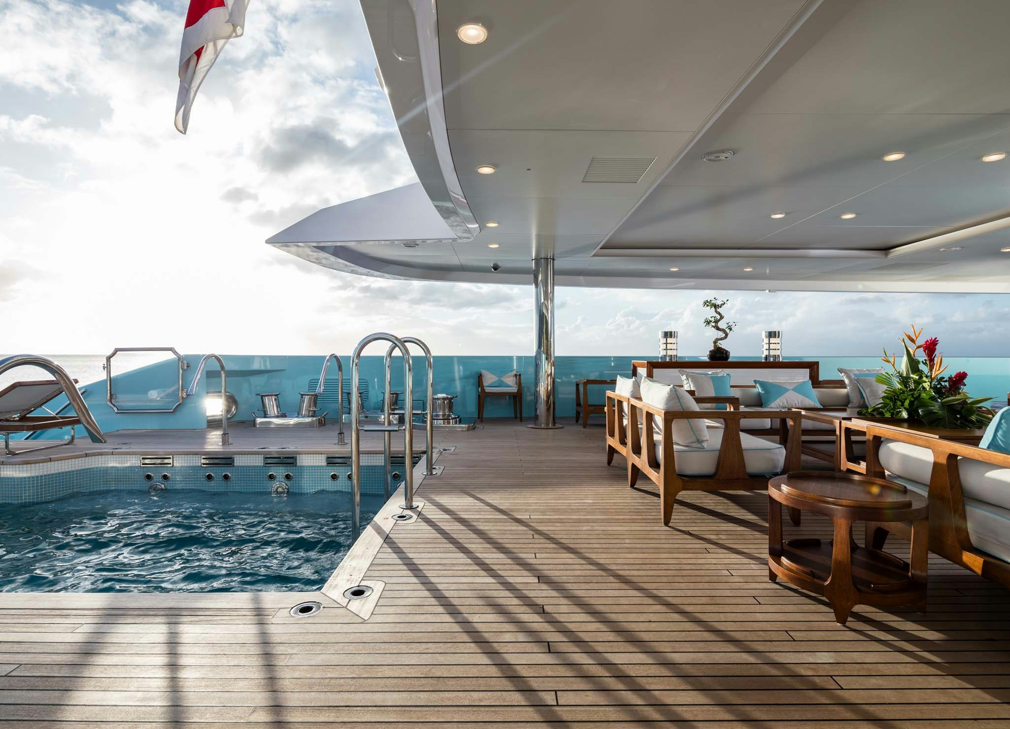 a pool with tables and chairs aboard AXIOMA Yacht for Charter