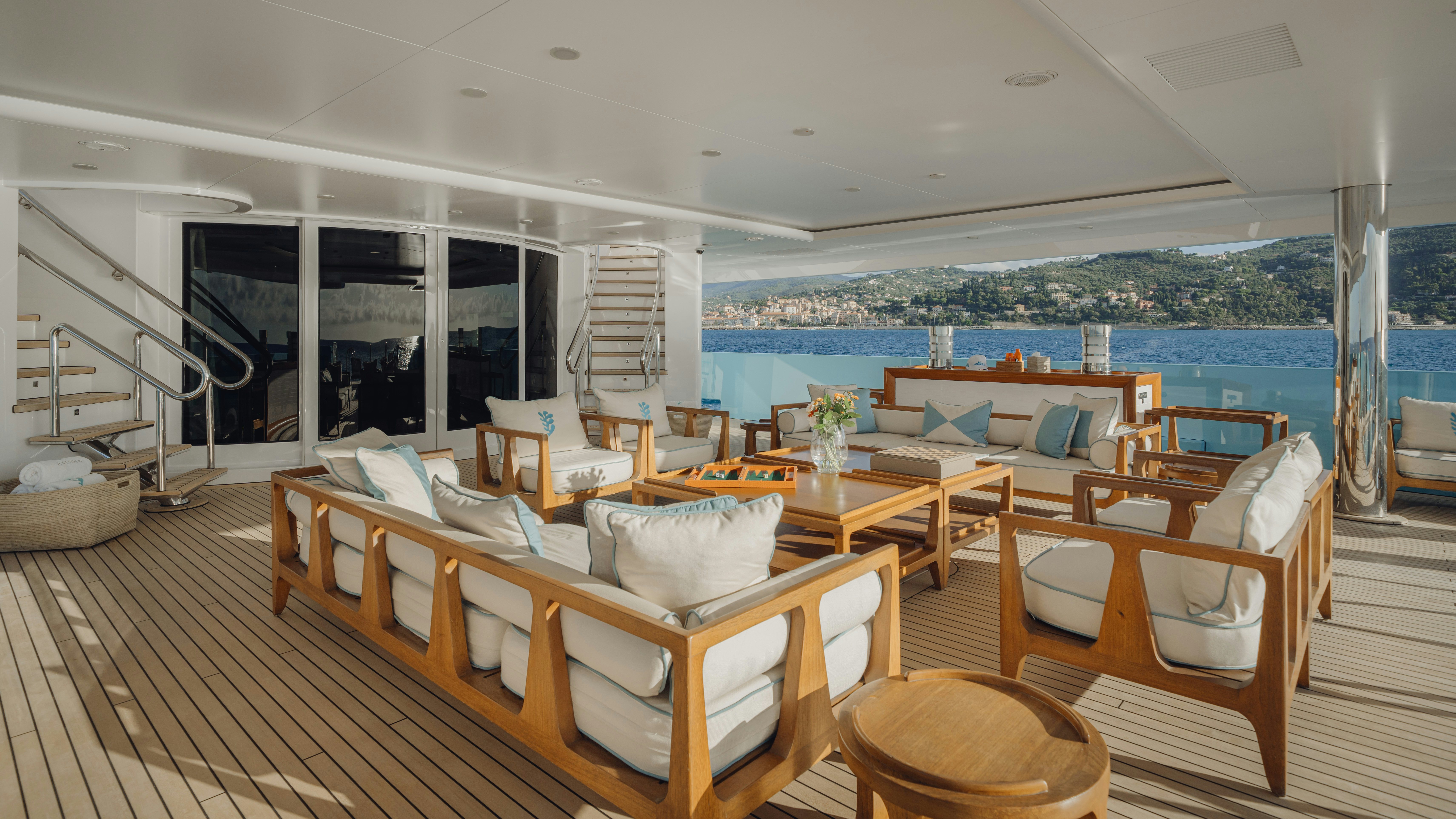 a room with a deck and chairs aboard AXIOMA Yacht for Sale