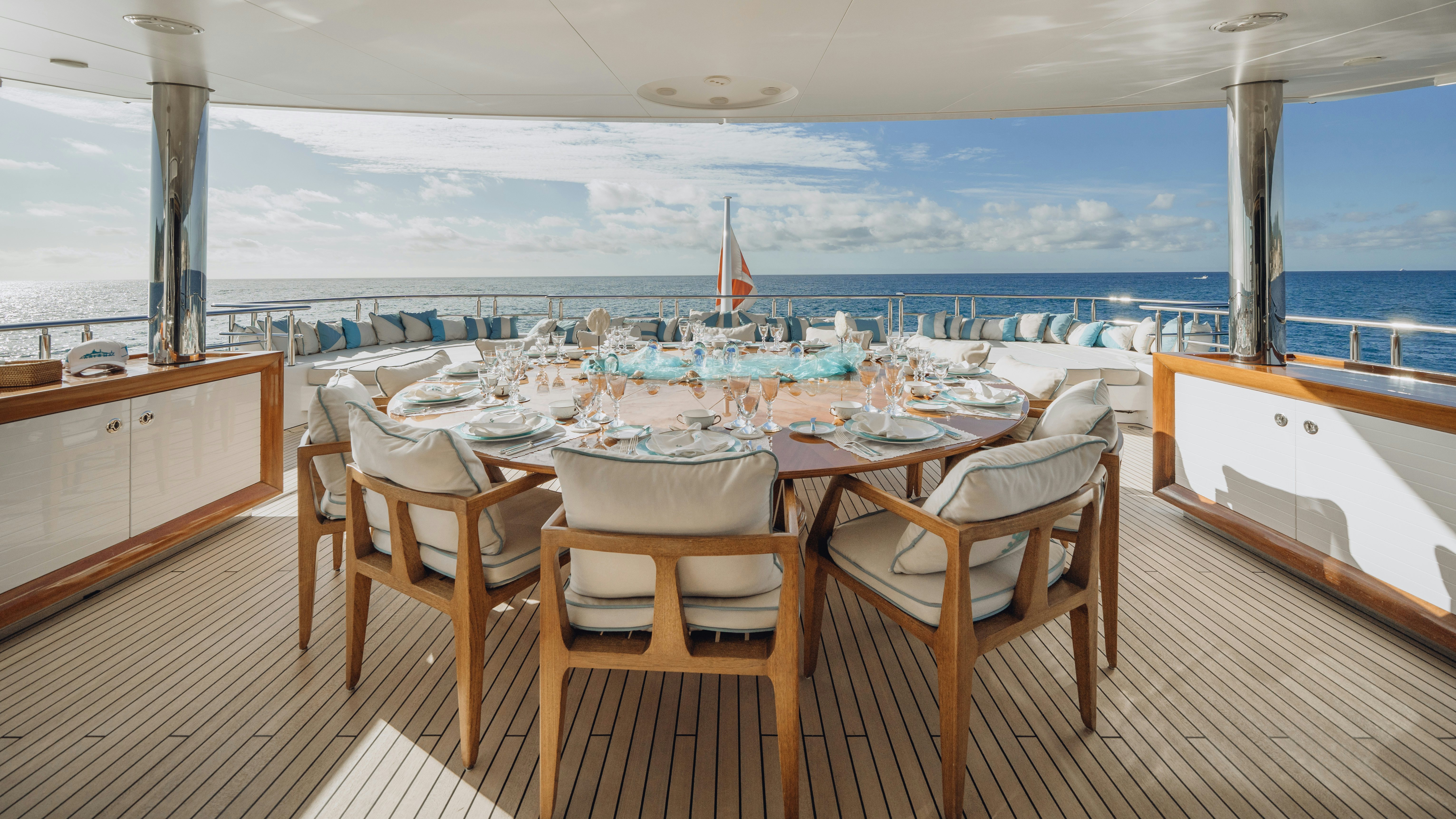 a room with a table chairs and a view of the ocean aboard AXIOMA Yacht for Sale