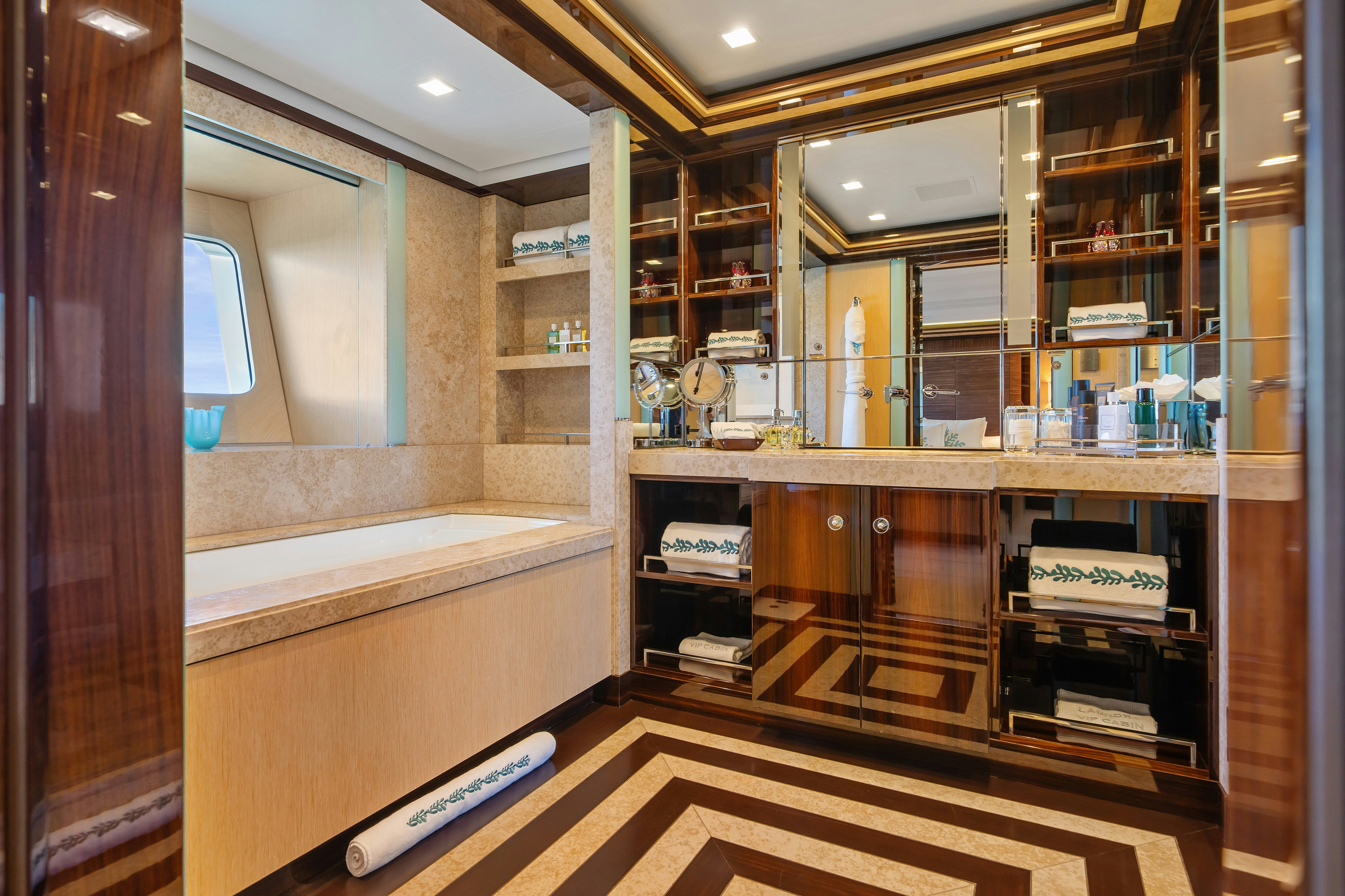 a room with a large mirror and a counter with a sink and cabinets aboard AXIOMA Yacht for Sale