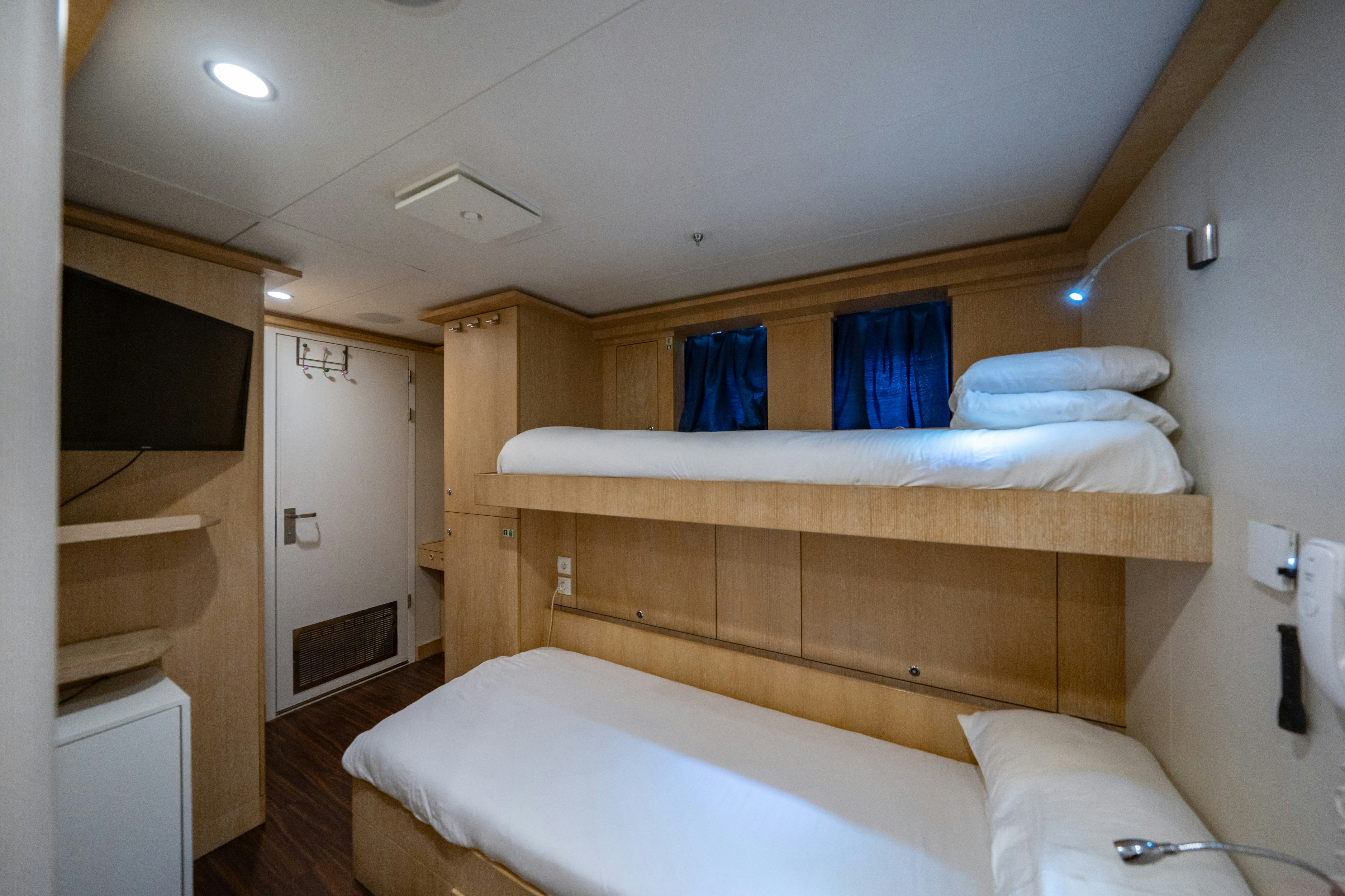 a bedroom with a bed and a television aboard AXIOMA Yacht for Sale