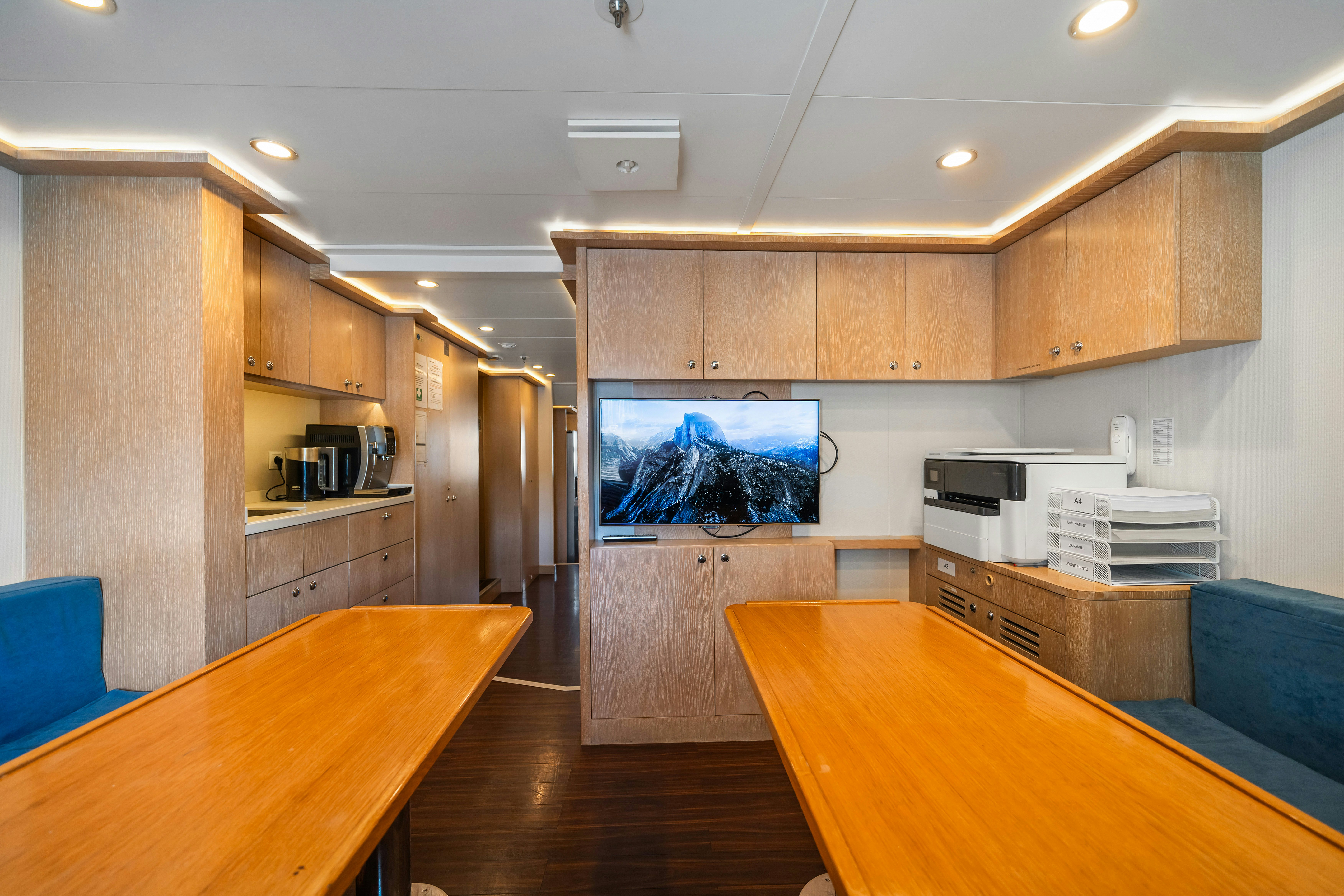 a kitchen with a table and a tv in the middle aboard AXIOMA Yacht for Sale