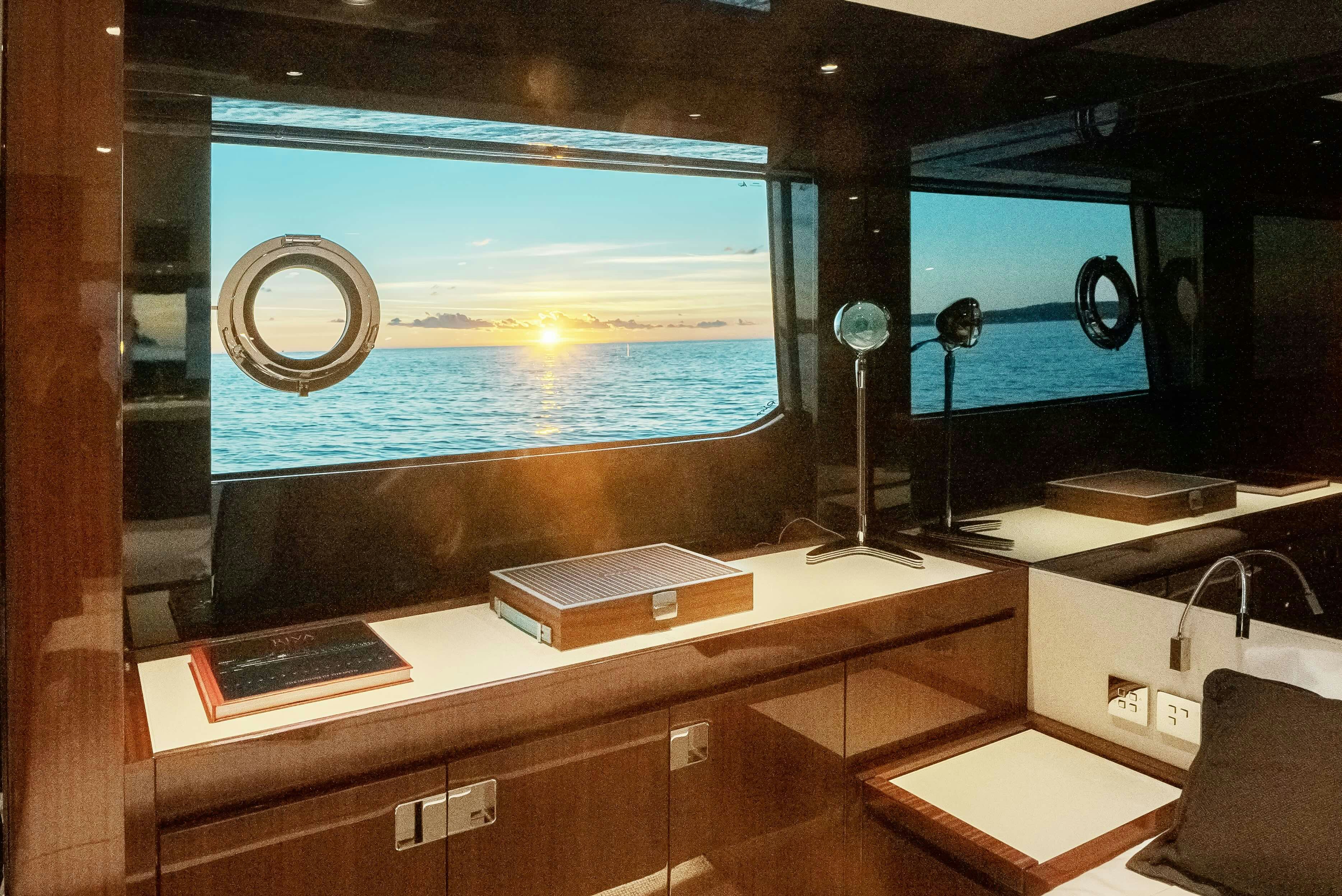 a room with a large window and a desk with a computer and a large blue ocean aboard DIABLE Yacht for Sale