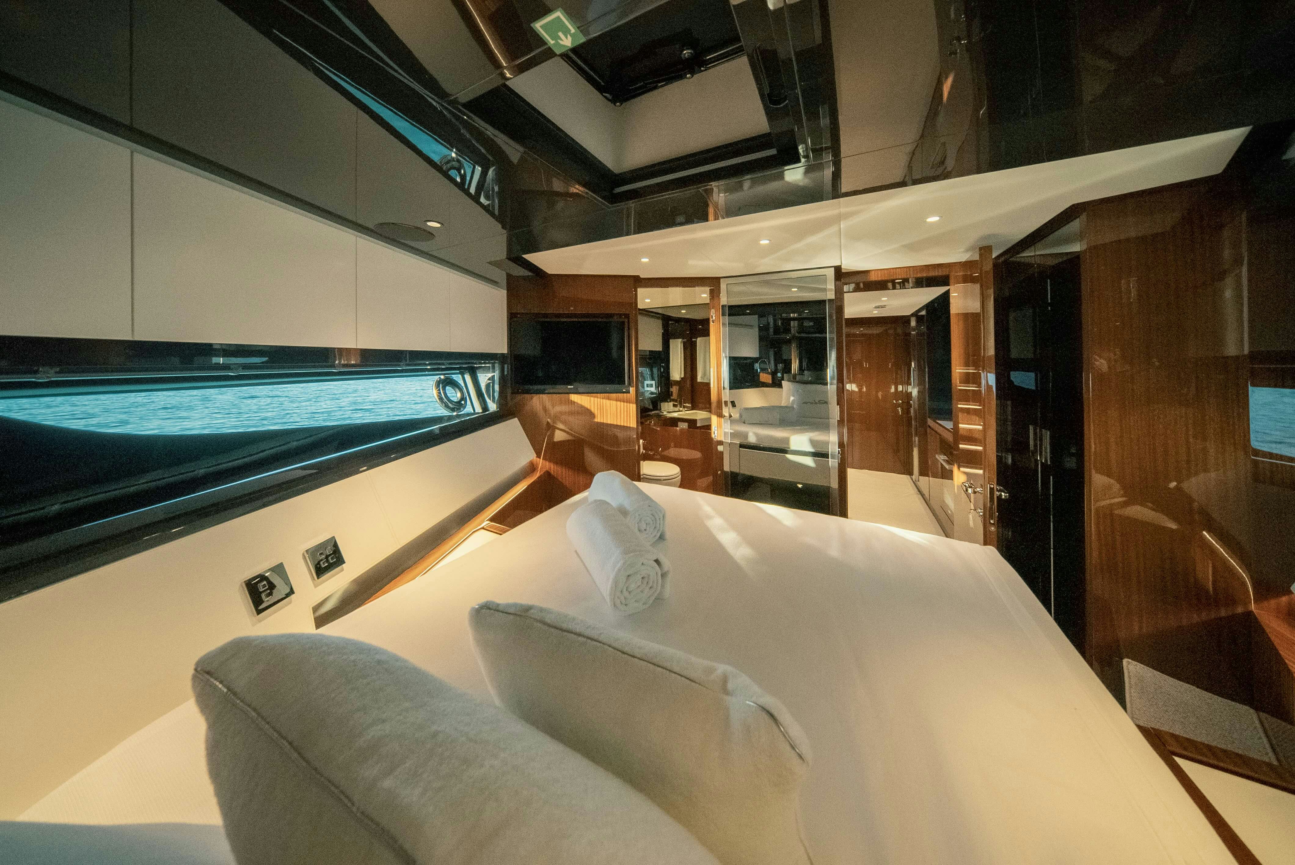 a room with a bed and a tv on the wall aboard DIABLE Yacht for Sale
