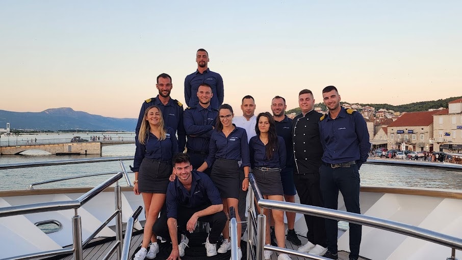 a group of people posing for a photo on a boat aboard BELLA Yacht for Charter
