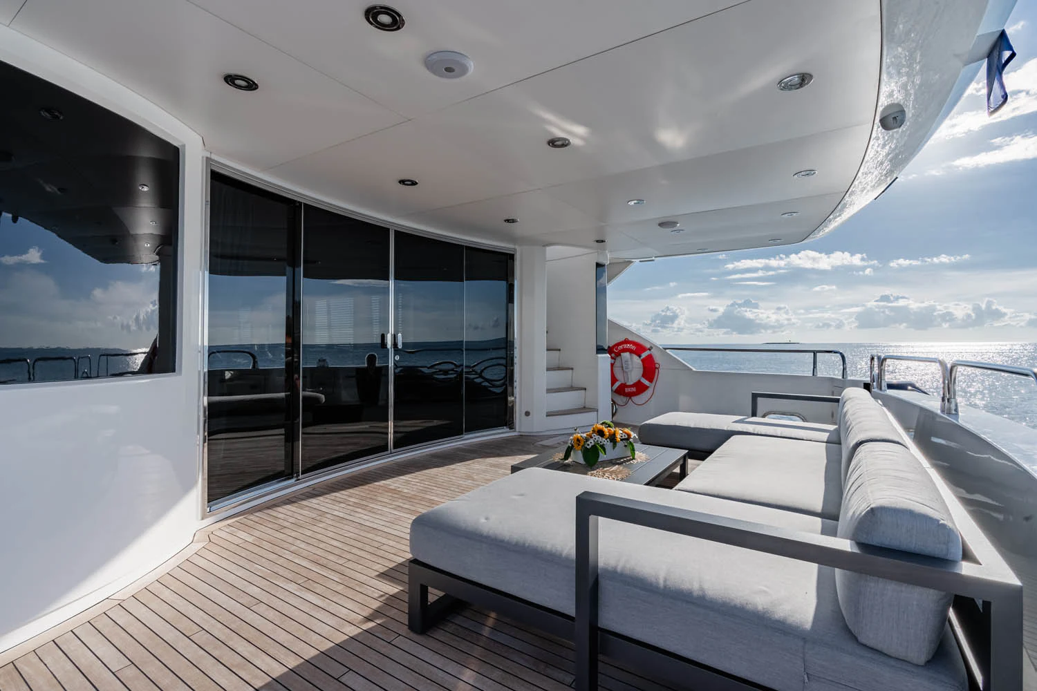 a room with a large window and a bed with a red balloon aboard LUNA ROSSA Yacht for Charter