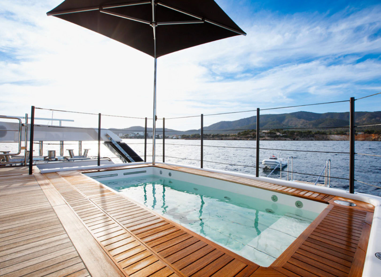 a deck with a large umbrella aboard PERLA BIANCA Yacht for Charter