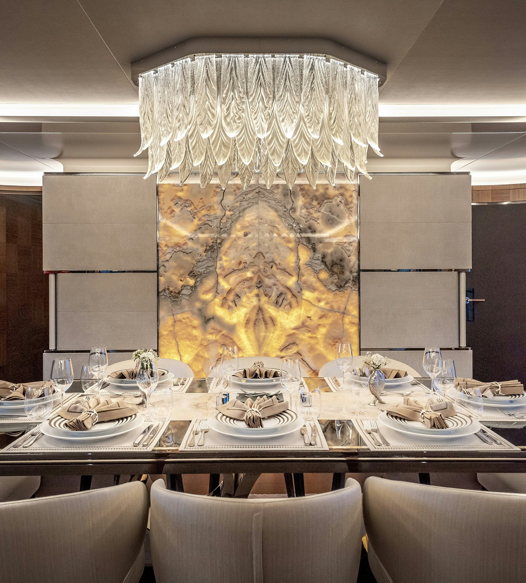 a large chandelier over a table with plates and chairs aboard SUNRISE Yacht for Sale