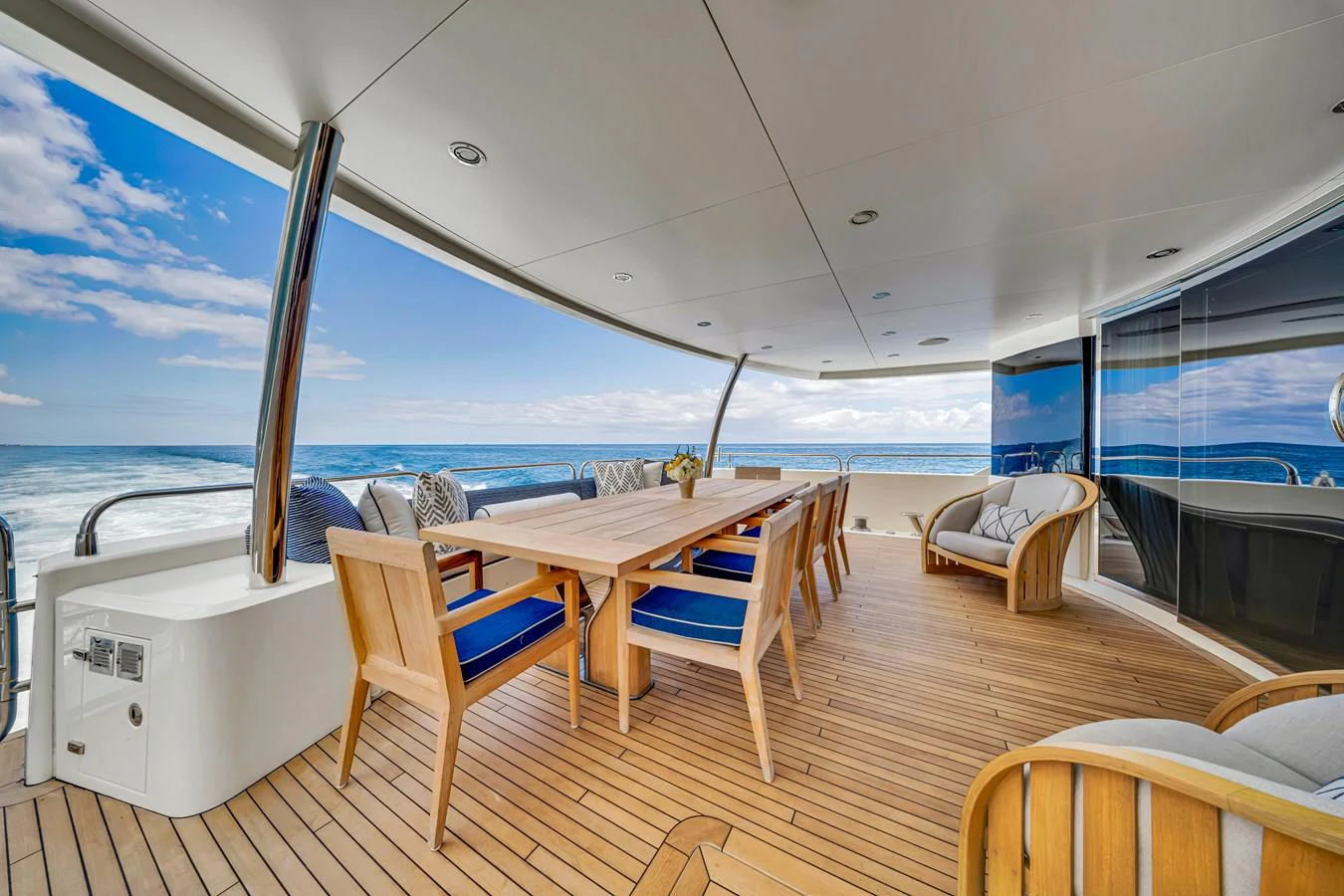 a deck with a table and chairs on it aboard NATURAL 9 Yacht for Charter