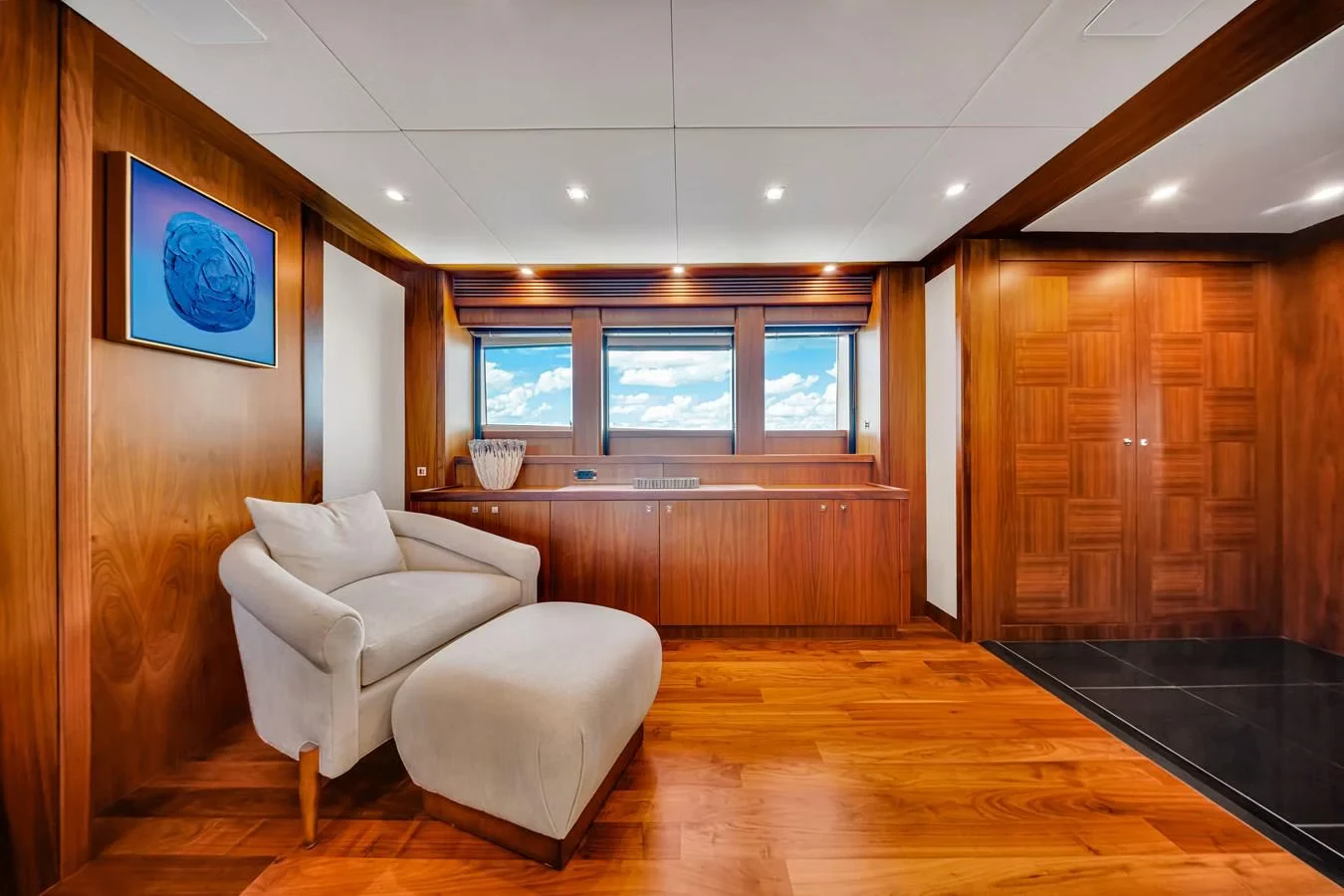 a room with a wood floor and a couch and a wood cabinet aboard NATURAL 9 Yacht for Charter