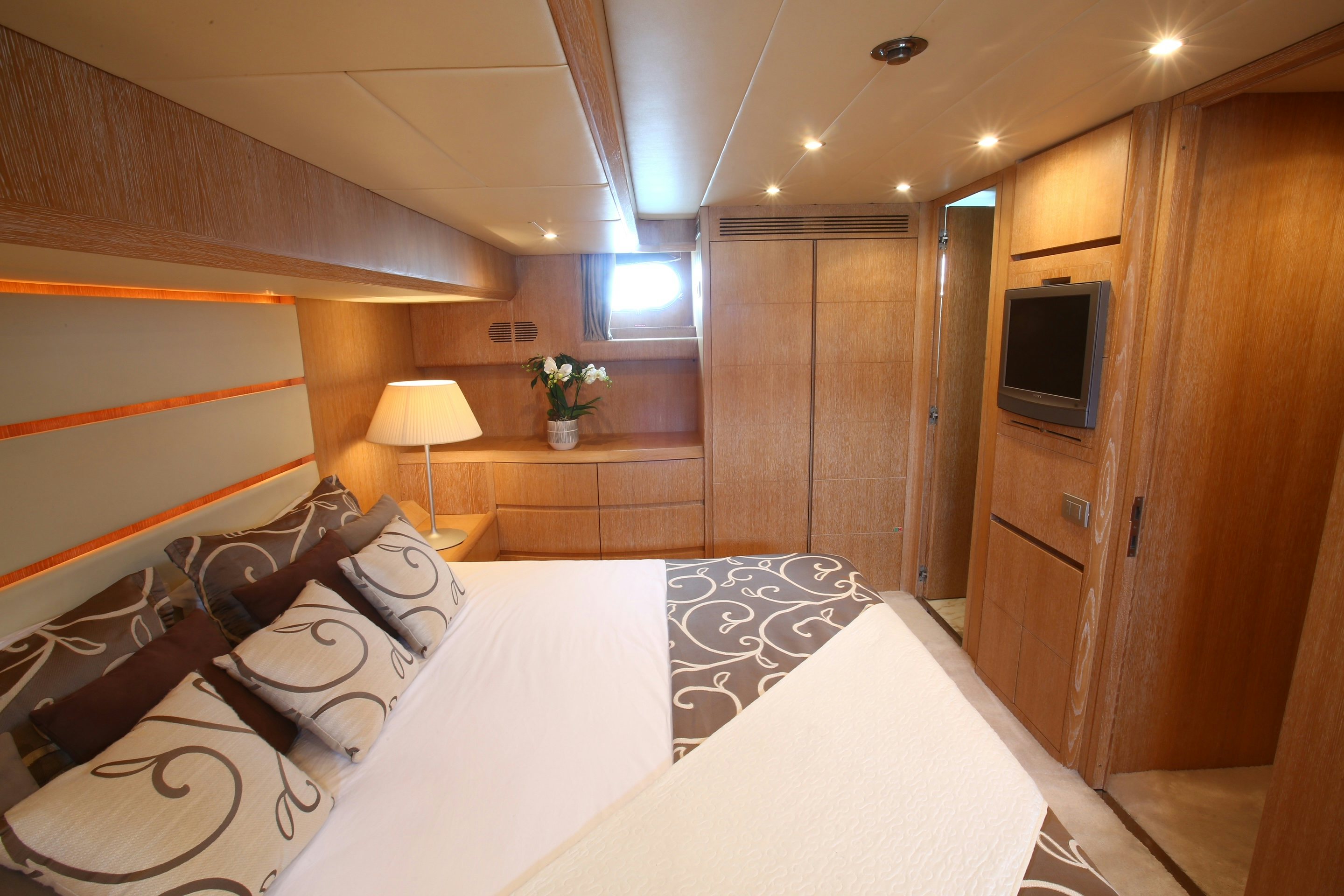 a room with a bed and a television aboard YAKOS Yacht for Sale