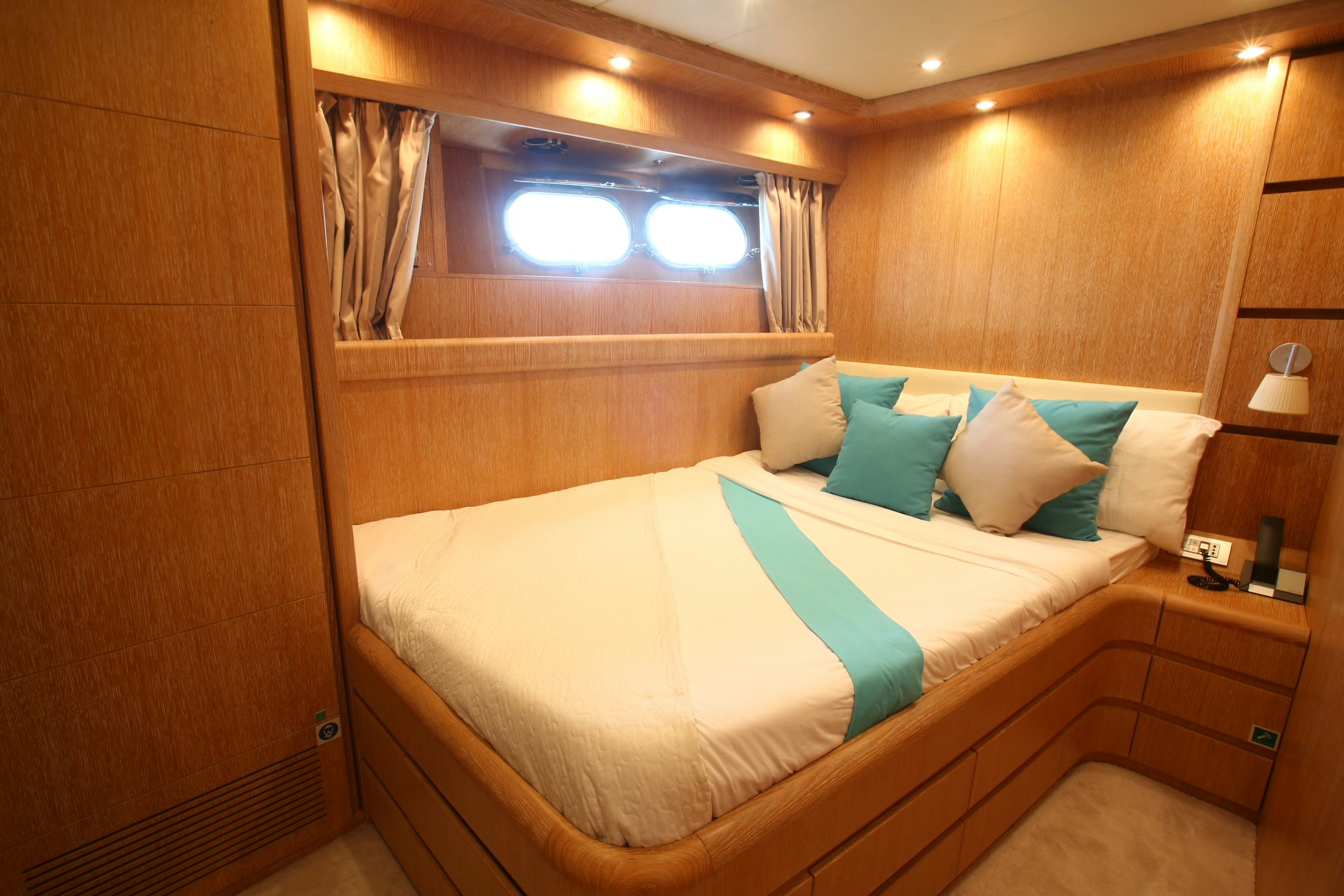 a bed with pillows and a window aboard YAKOS Yacht for Sale